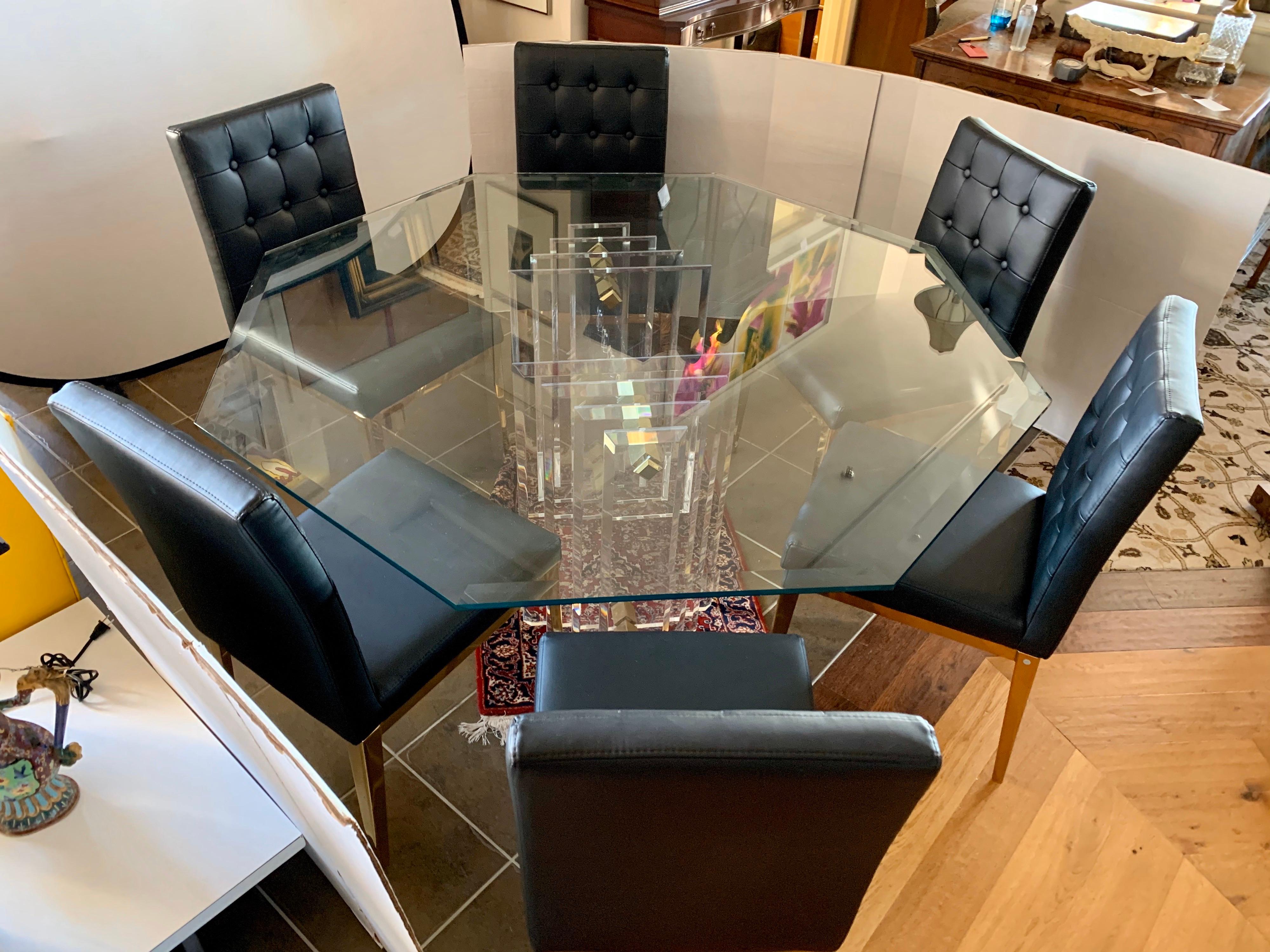 Stunning Charles Hollis Jones Lucite, brass and glass dining table where the glass top is
eight sided and round. The skyscraper base is made of Lucite and brass and is exquisite.
The base is two separate pieces that support the thick glass top