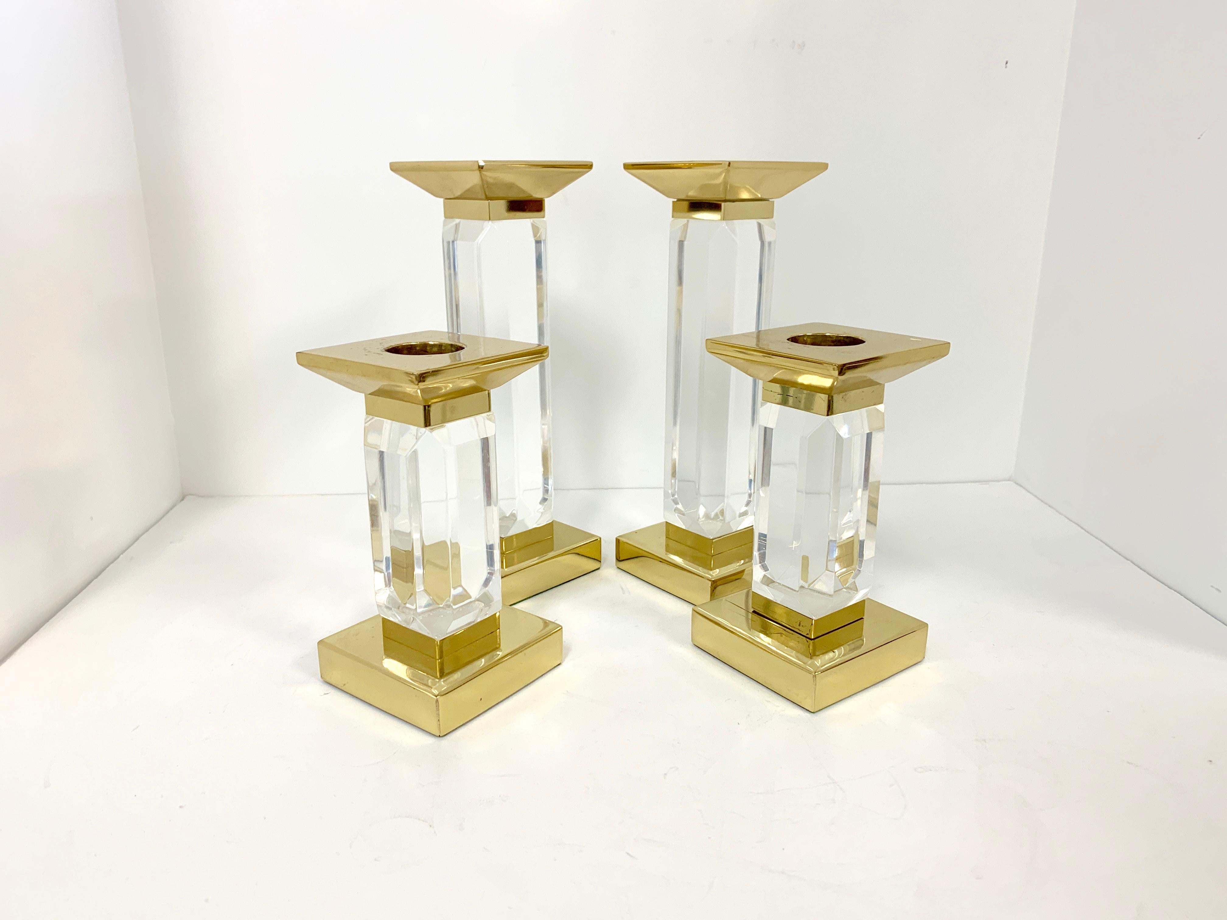 Two pairs of Charles Hollis Jones Lucite and brass candlesticks, candleholders. These are vintage midcentury pieces. They are in good age appropriate condition with some marks to the brass, wax residue from use and marks and some cloudiness from age