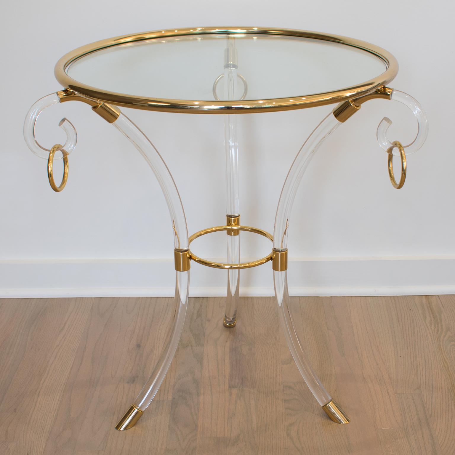 Charles Hollis Jones designed this lovely Mid-Century modernist Lucite and brass coffee or side table. The round Directoire style pedestal table has clear Lucite and gilded brass resting on three arched feet with an upper part in the form of volutes