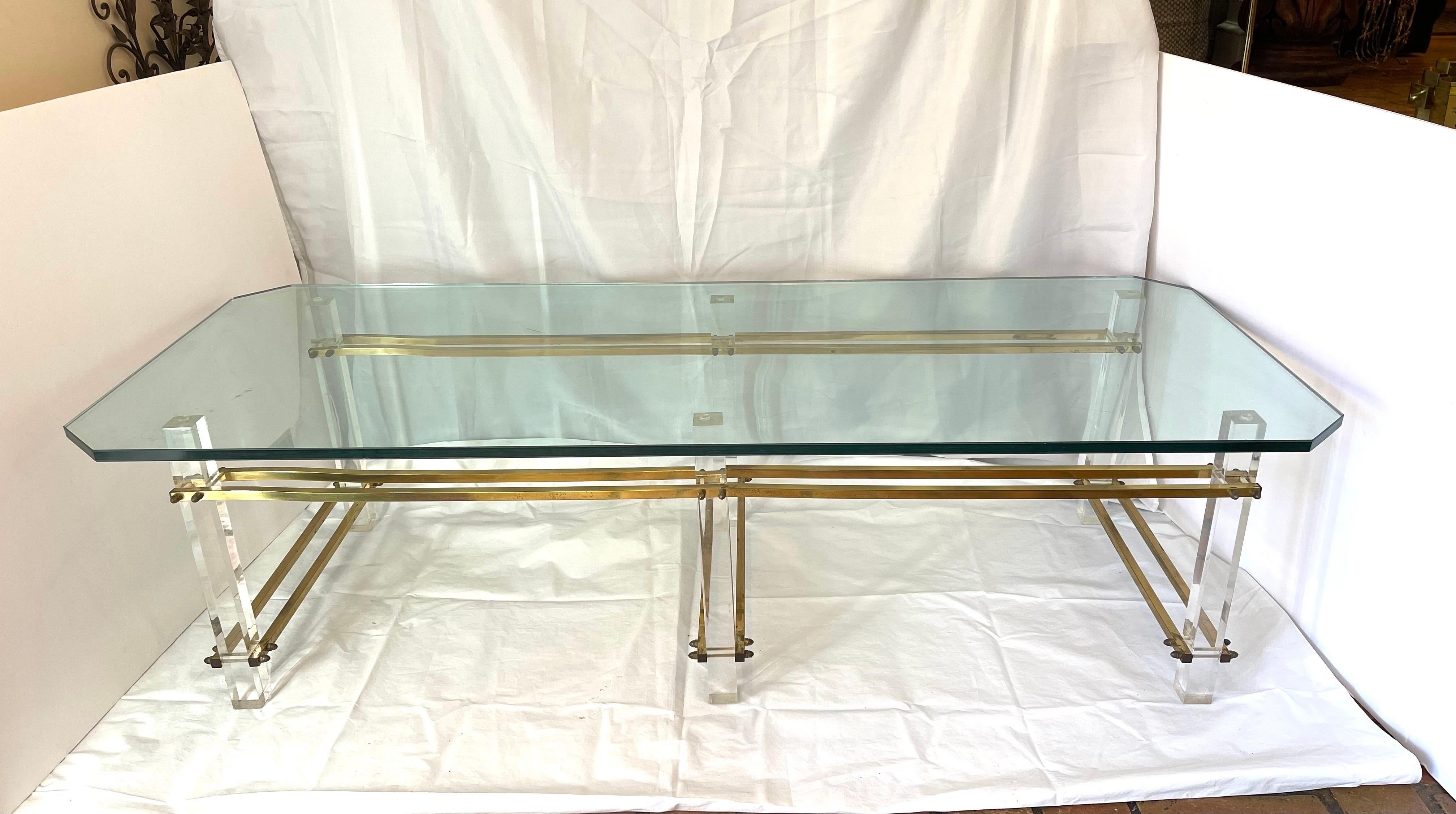 Stunning Charles Hollis Jones Lucite, brass and glass coffee table. Thick rectangular glass top with corner cut  edges. This sleek Hollywood Regency style table is the epitome of glam and will dress up any living room or office. The glass top is