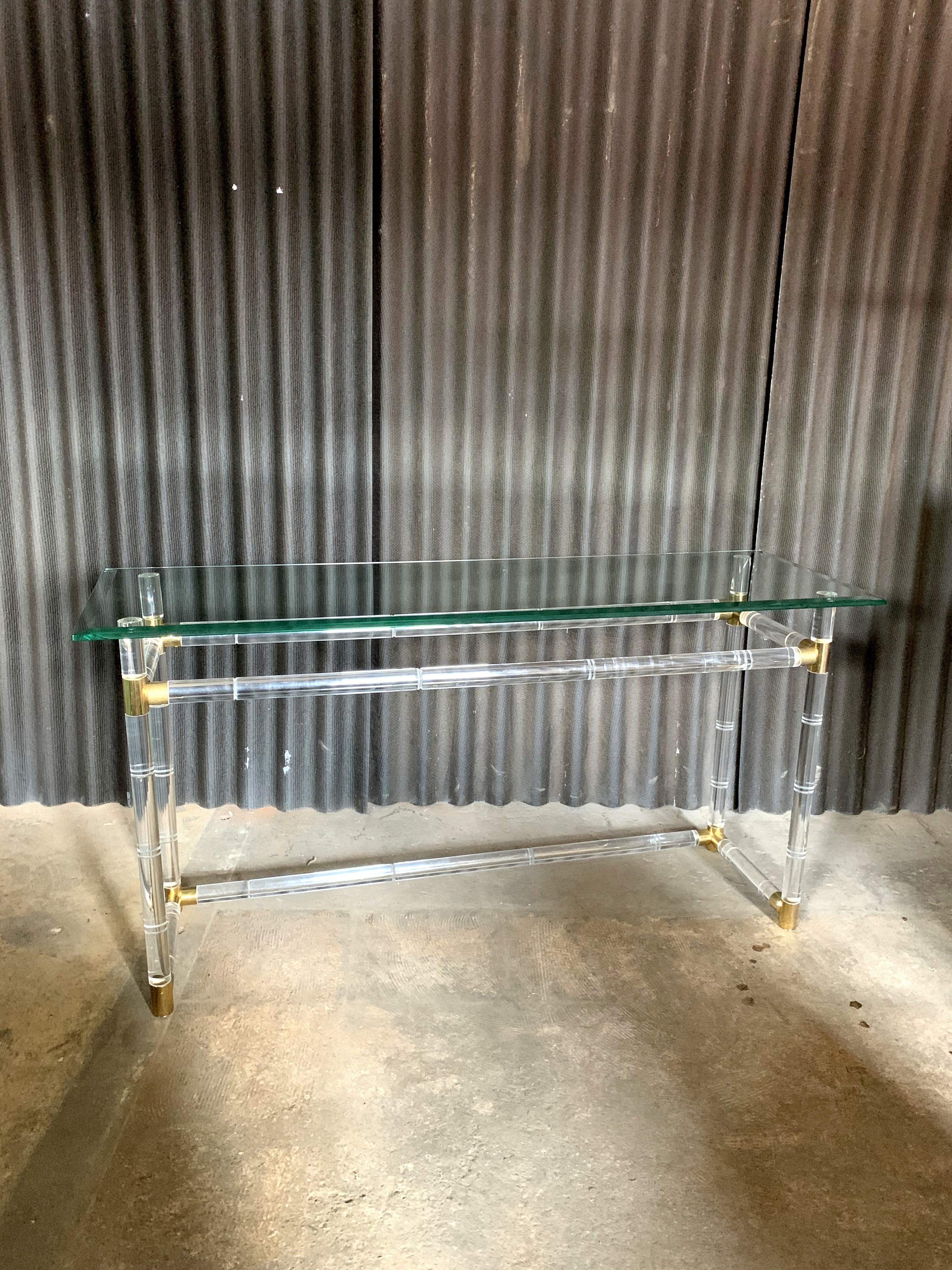 Beautiful Lucite and brass console by Designer, Charles Hollis Jones.
Base and glass and are in incredible condition.
No chips or breaks anywhere.
Light scratches and then light wear to one base as shown in photo.
Beveled glass is original to