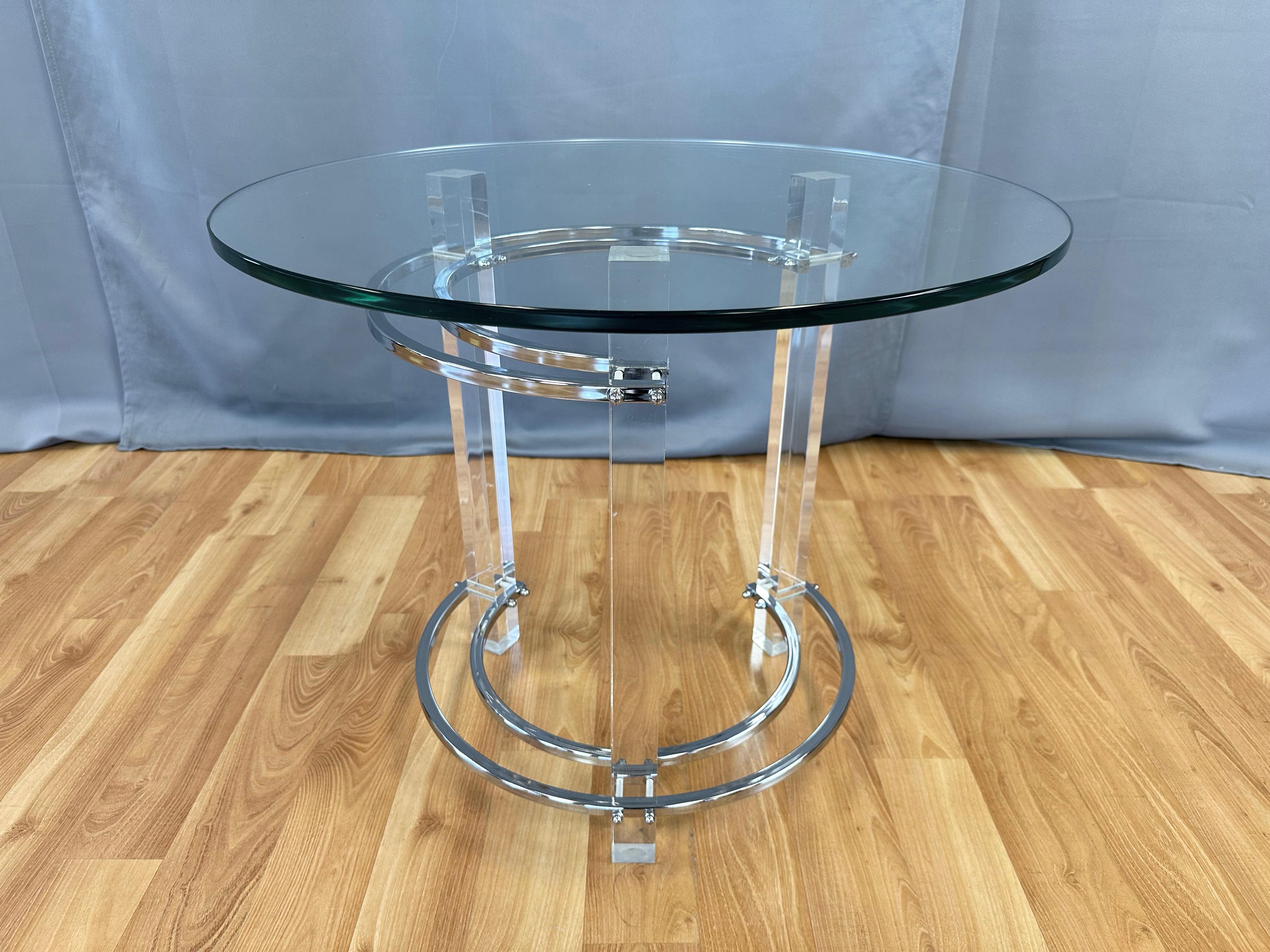 A fabulous 1970s Hollywood Regency-meets-Minimalist lucite and chrome side table or end table with glass top by Charles Hollis Jones. 

A trio of crystal clear 1.63 in. sq. lucite columns is connected via two pair of chrome-finish concentric