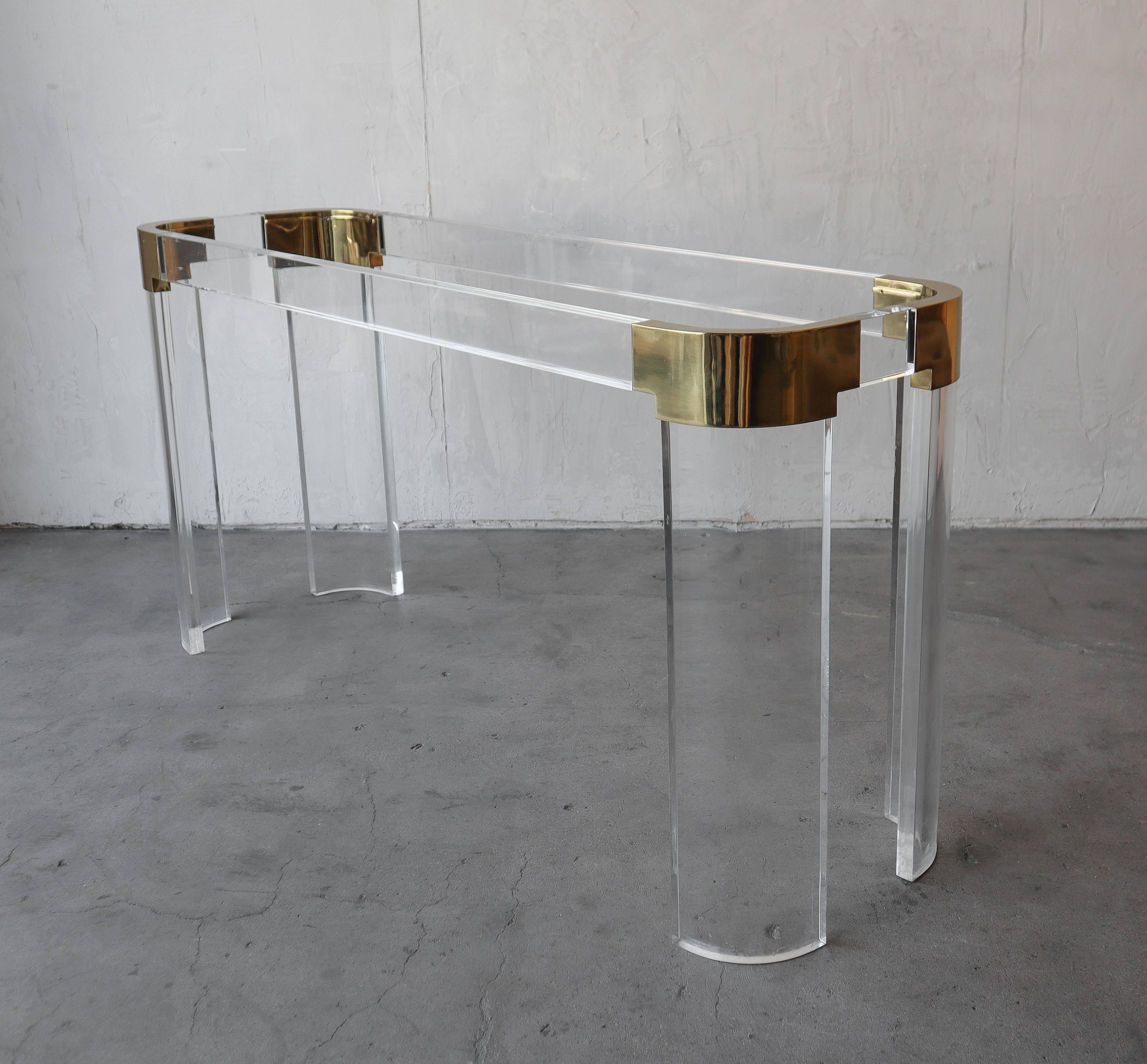 Rarely seen, Lucite and brass console table by Charles Hollis Jones, from his Waterfall collection in the 1970s.

This table is fairly substantial and in excellent condition overall.  There are a few small marks on the Lucite but nothing that