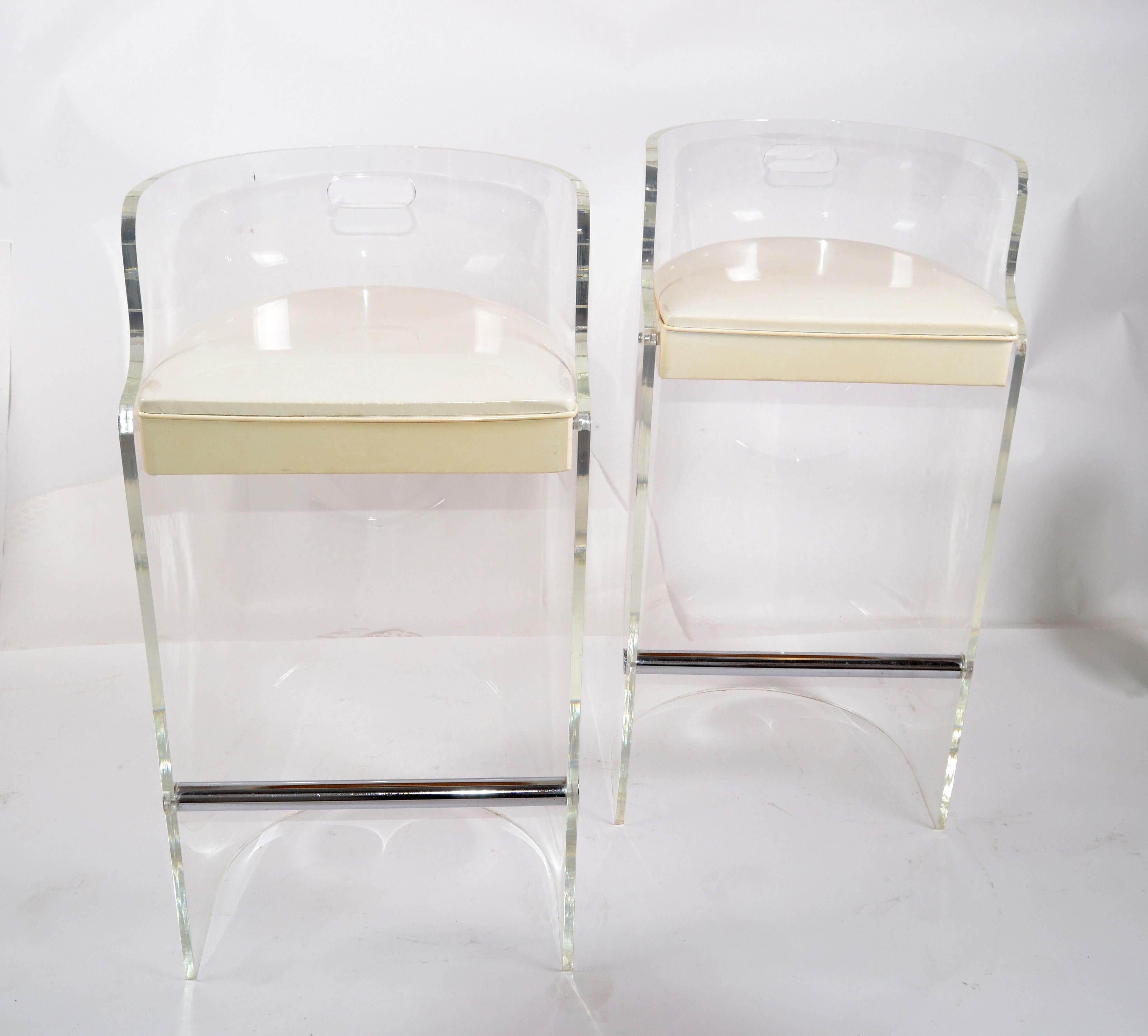 Pair of Mid-Century Modern Lucite and chrome bar stools designed by Charles Hollis Jones in the 1970s and made by Hill Manufacturing Corporation.
The bar stools have the original white patent leather seat upholstery.
The footrest is chrome, as