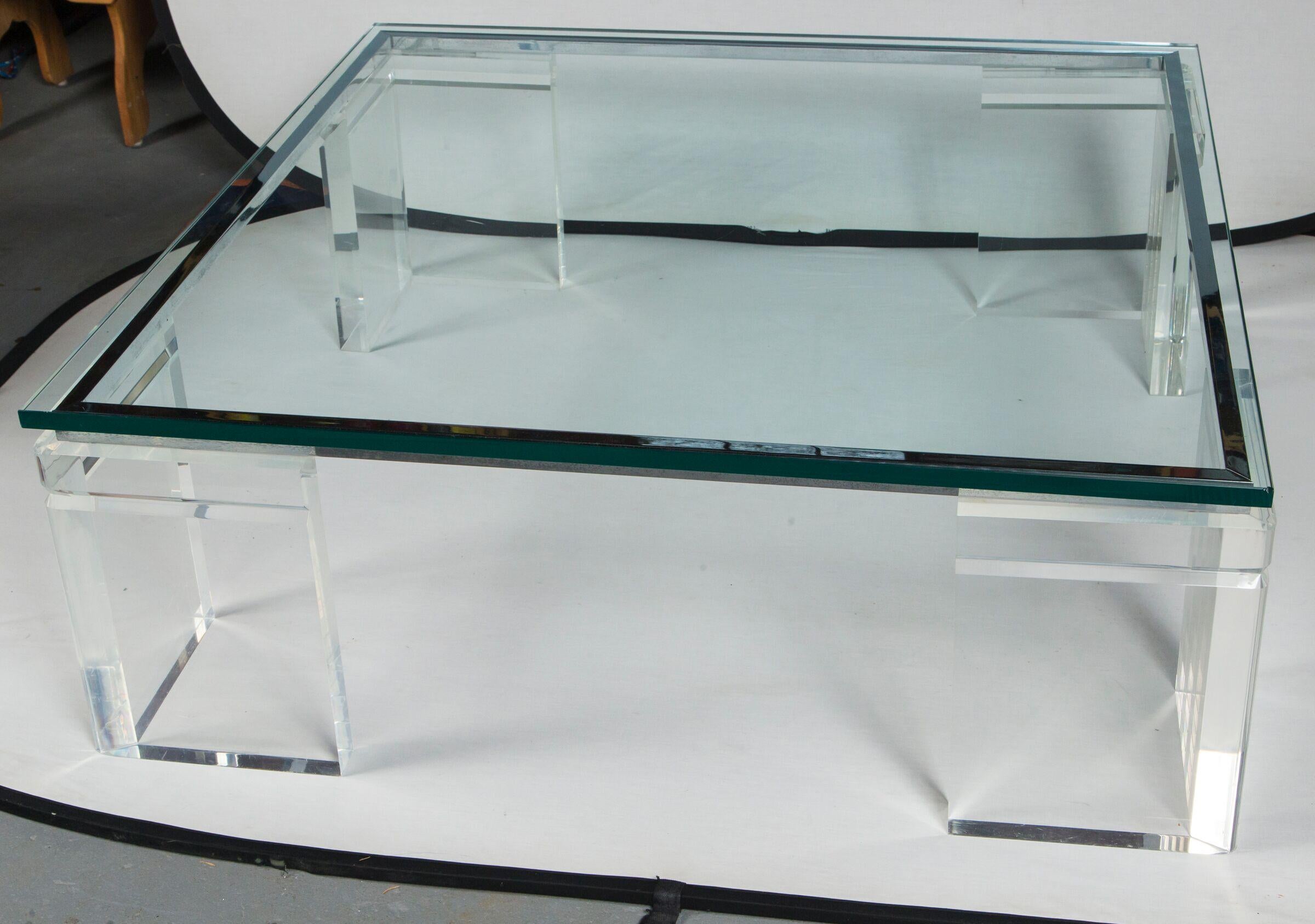 A monumental Charles Hollis Jones Lucite, chrome, and glass coffee table. The glass sits atop four very thick Lucite legs which are connected by 4 pieces of mitered chrome hardware. The top is thick glass with a flat polished edge and sits above the