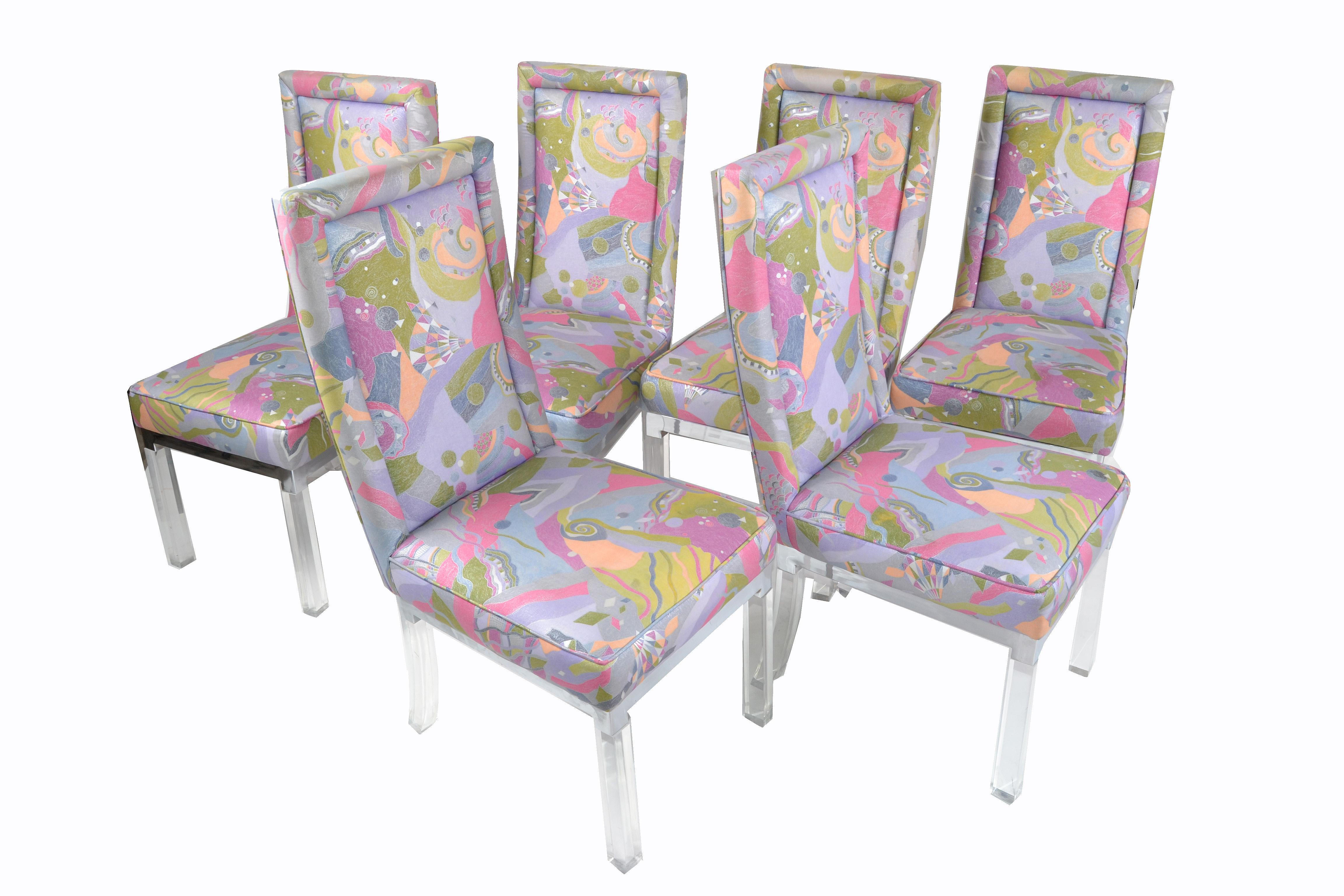 Lot de 6 chaises de salle à manger avec pieds en Lucite / acrylique, structure d'assise chromée et revêtement en tissu coloré.
Comme on nous l'a dit, il s'agit du tissu d'origine et il présente une légère usure et des petites déchirures sur deux