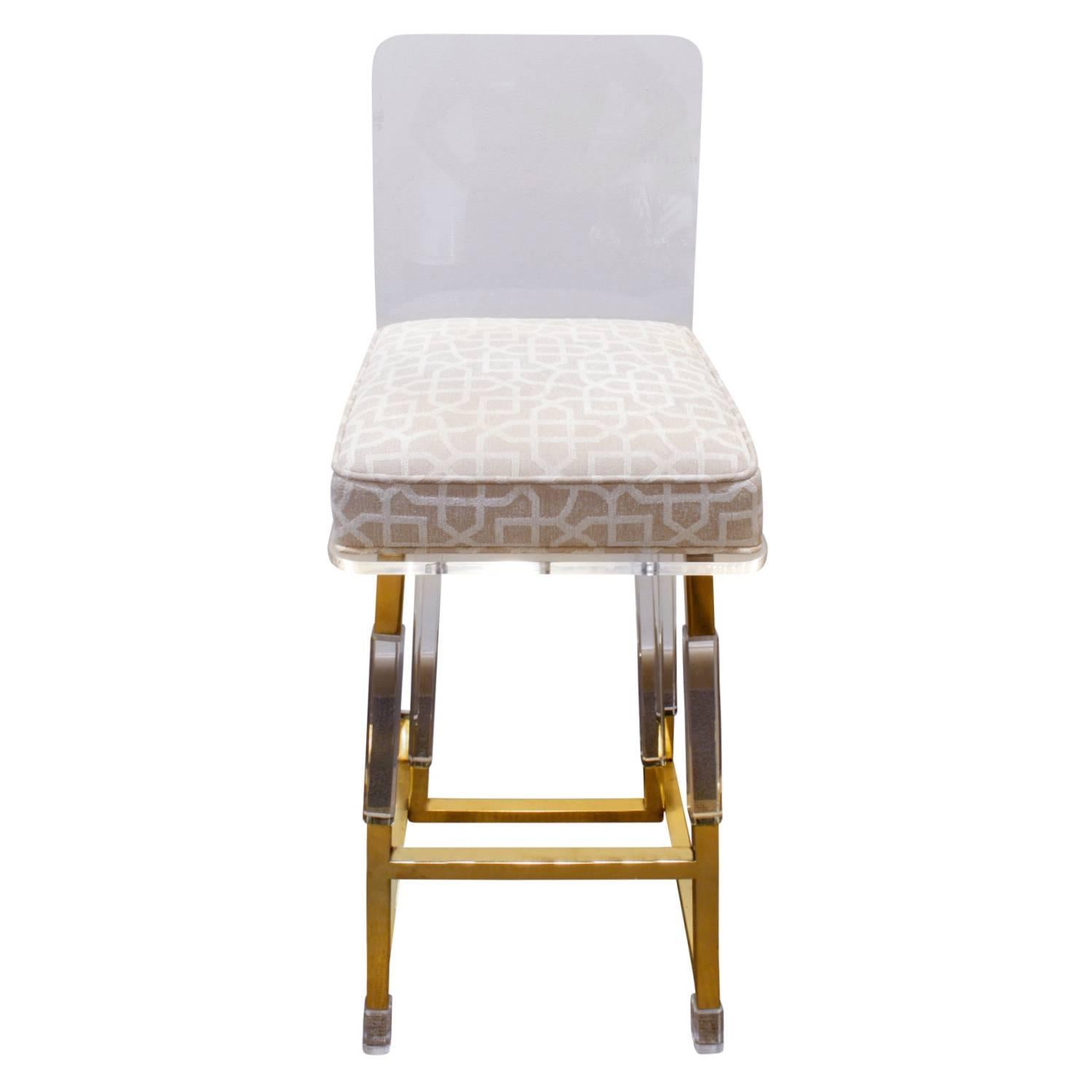 Set of three swivelling bar stools in Lucite and brass with upholstered seat by Charles Hollis Jones, Metric Line, American 1970s. These are newly upholstered by Lobel Modern.