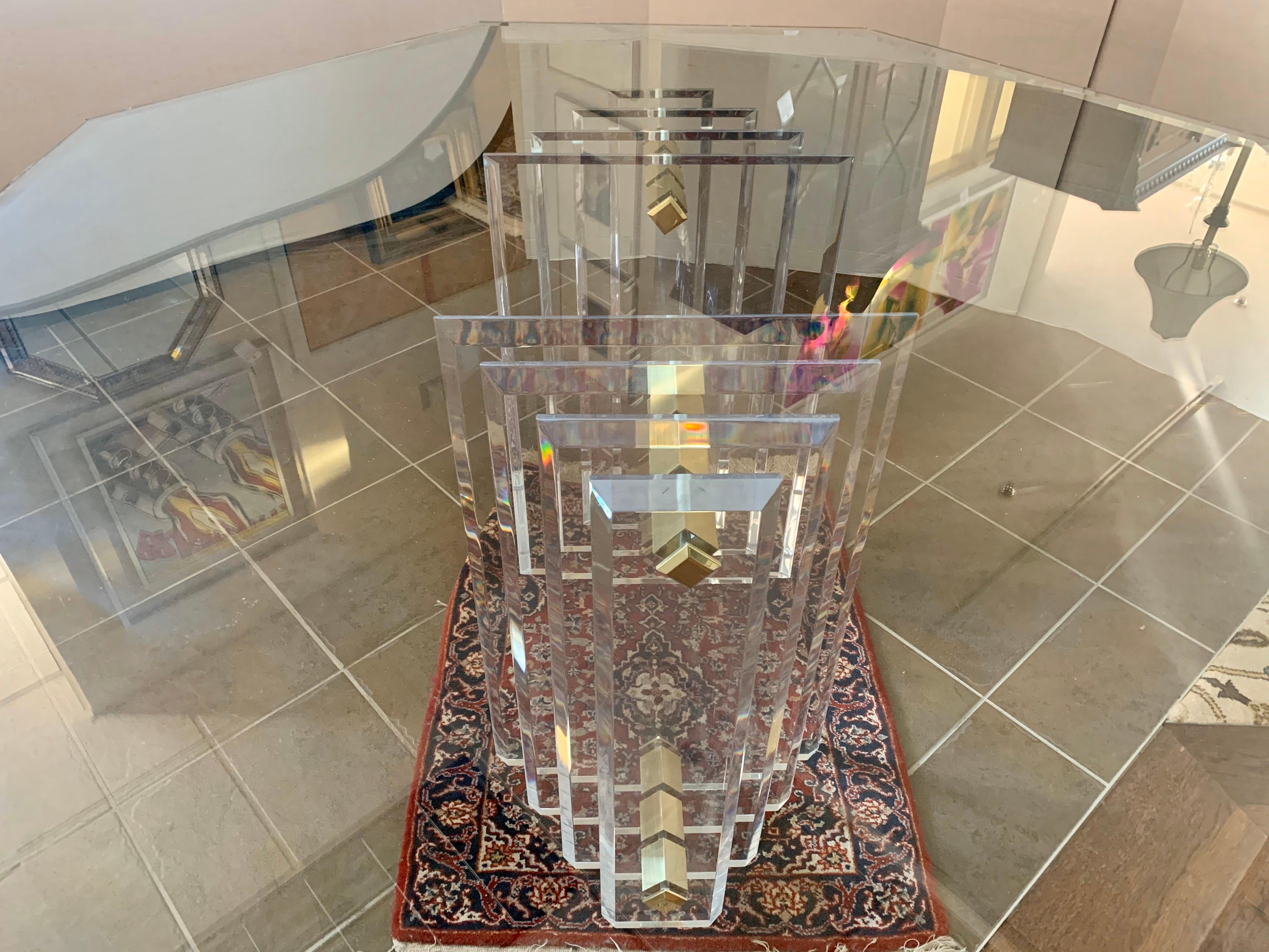Stunning Charles Hollis Jones Lucite brass and glass eight sided dining table. The skyscraper base is made of lucite and brass and is exquisite.
The base is two separate pieces that support the one half inch thick glass top.
This is a true period