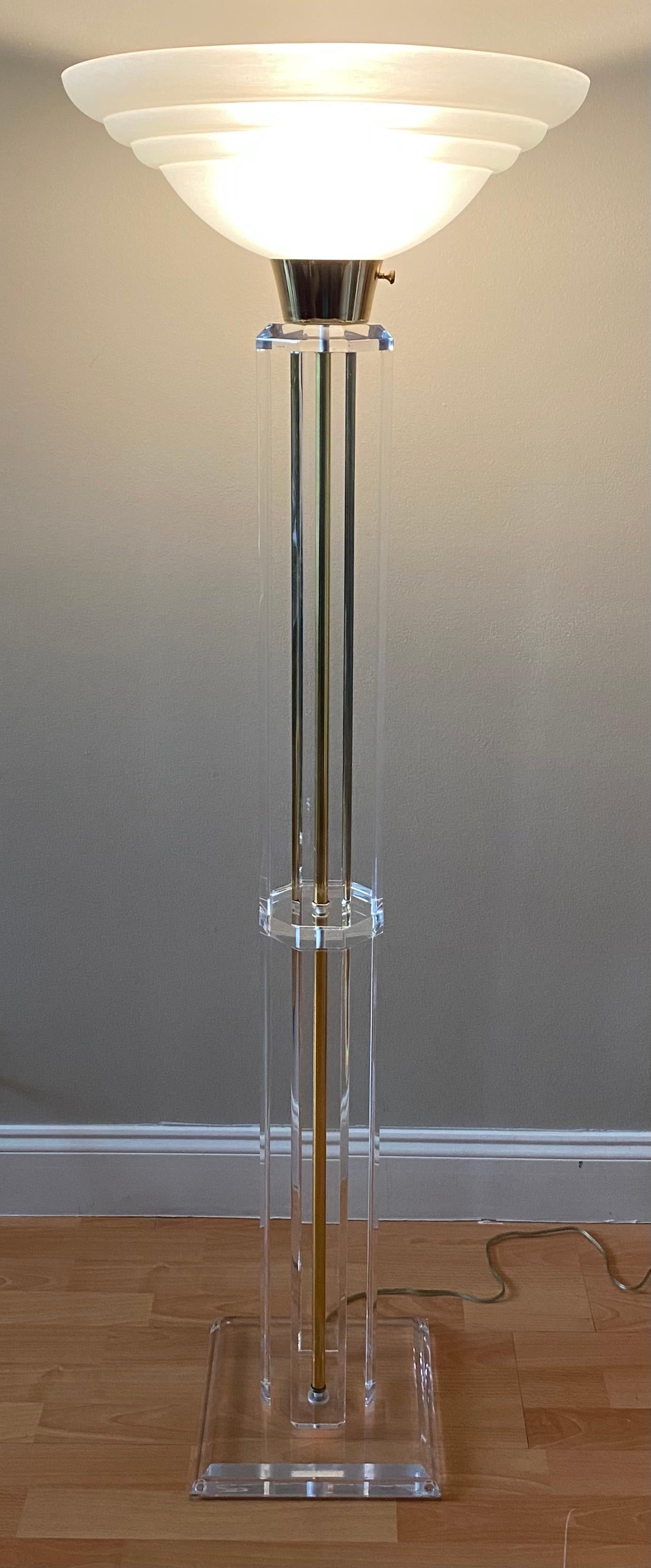 Stylish floor lamp in lucite and brass in the style of pieces designed by the lucite icon, Charles Hollis Jones.

This beautiful lamp is part of lines designed in the 1970s.  It is in very good condition and proper working order that illuminates