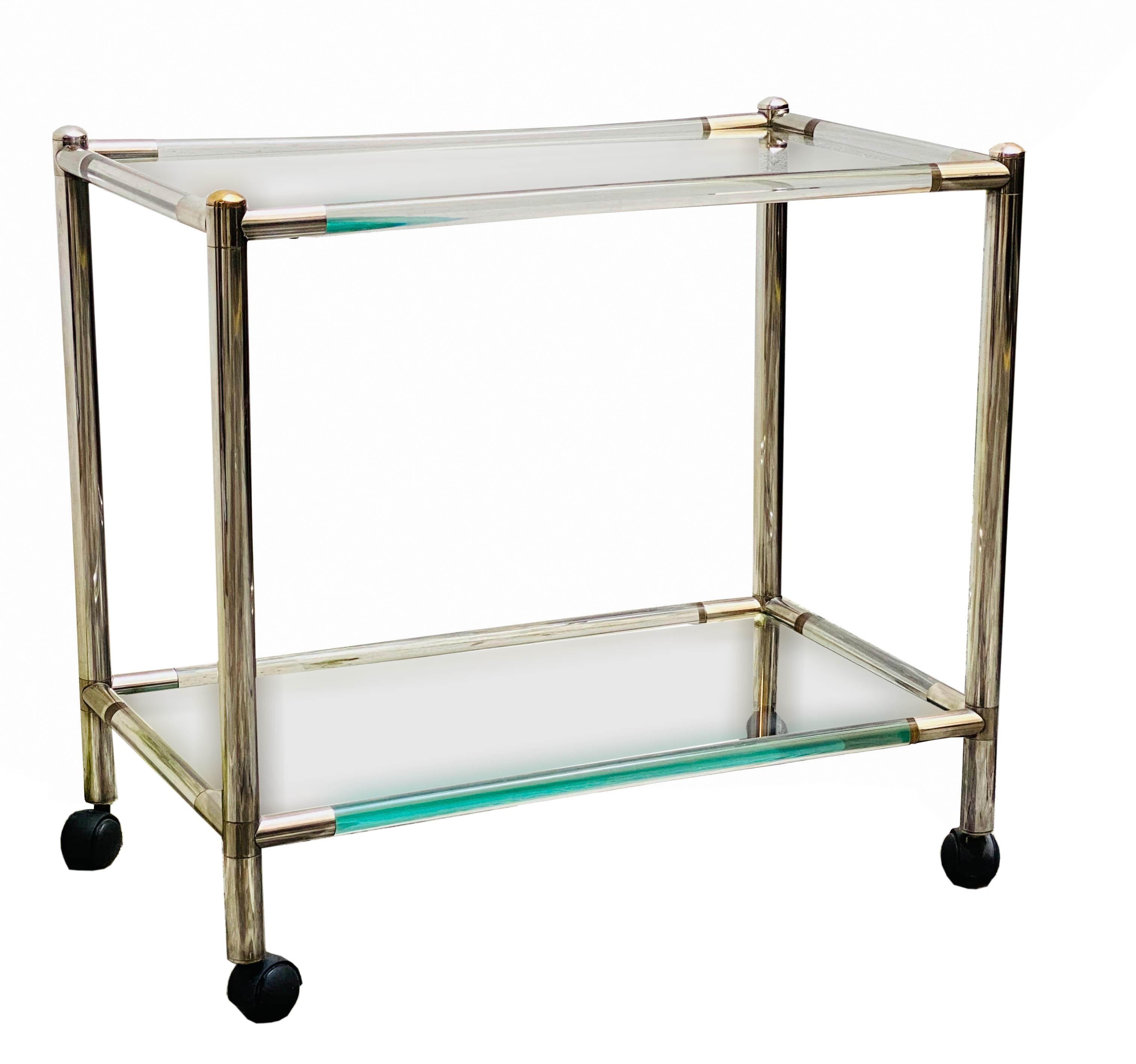 Lucite bar trolley, it has two internal transparent glass shelves that rest on black swivel wheels, the details are chrome-plated. Italian manufacture 1970.



