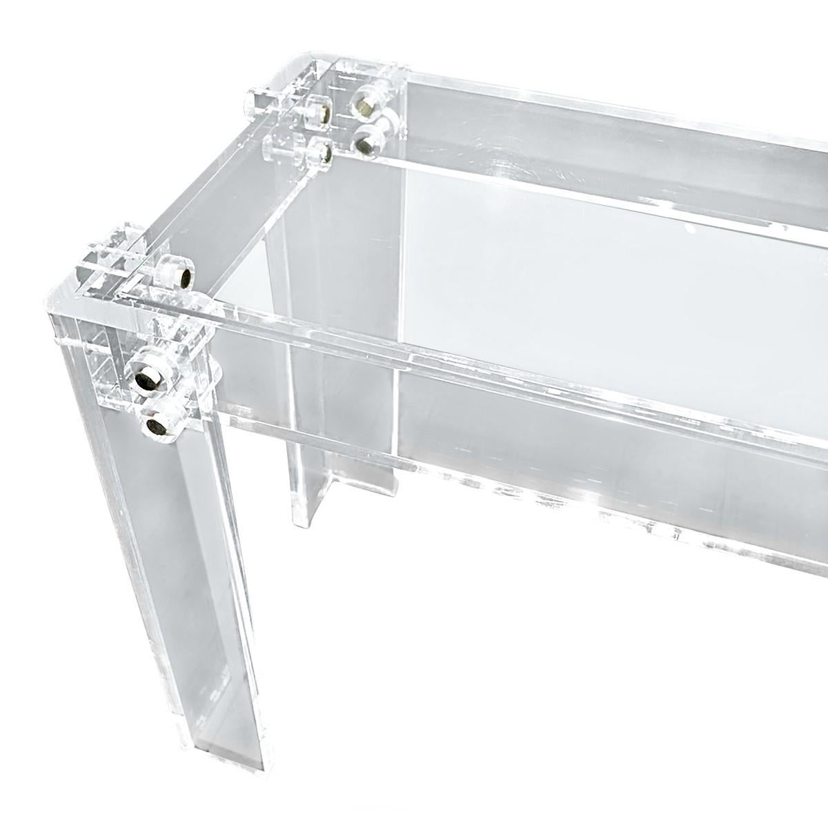 Sculptural Mid-Century Modern Lucite console or sofa table with center rod stretcher and bolted trim details. Thick Lucite frame supports a removable glass top. In the style of Charles Hollis Jones.
