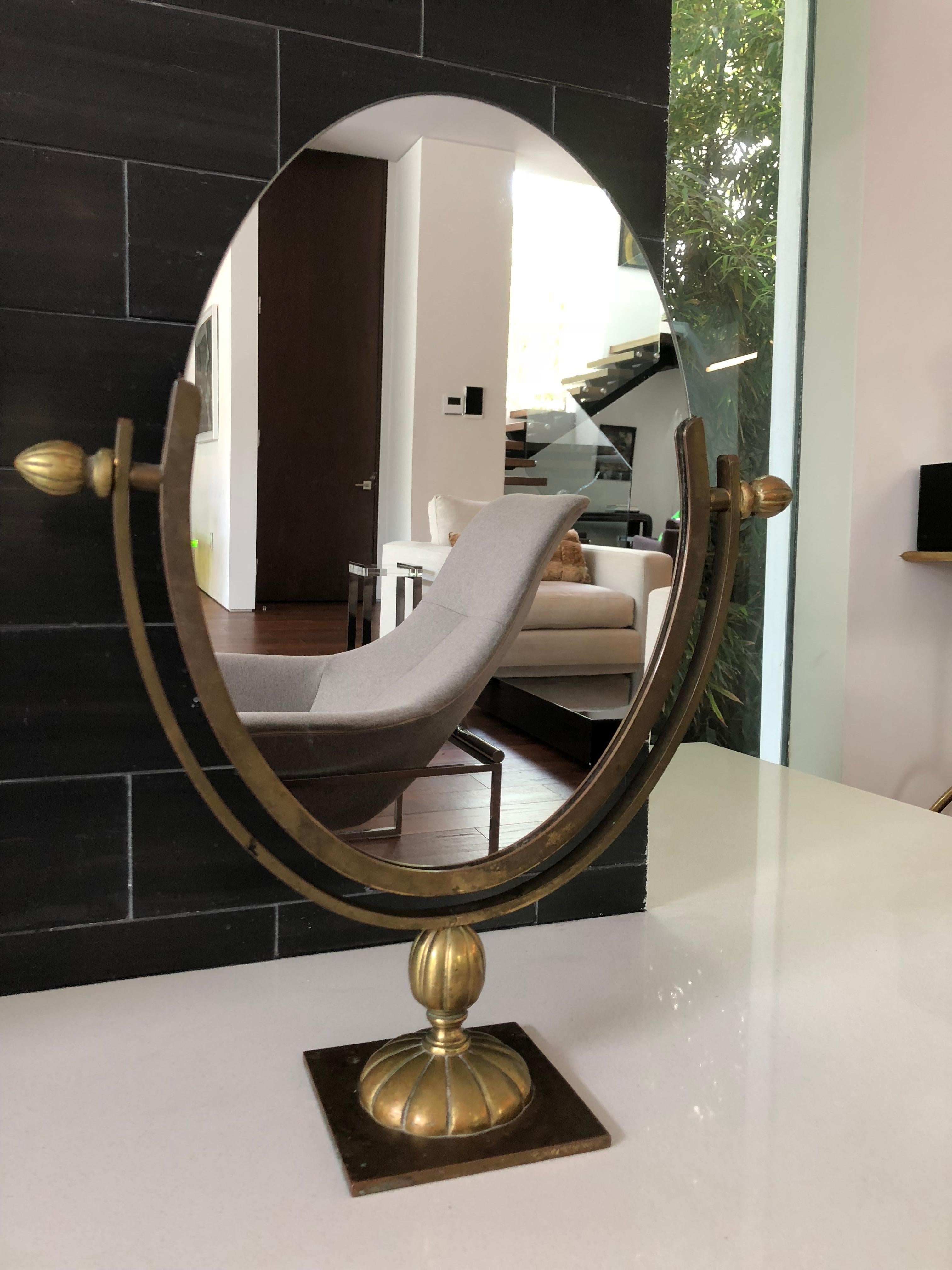 Beautiful oval mirror designed and manufactured by Charles Hollis Jones in the 1960s. The mirror has an antique brass finished frame and base, the mirror is double sided and it can be flipped to be used on either side.
Measures: 19 1/2