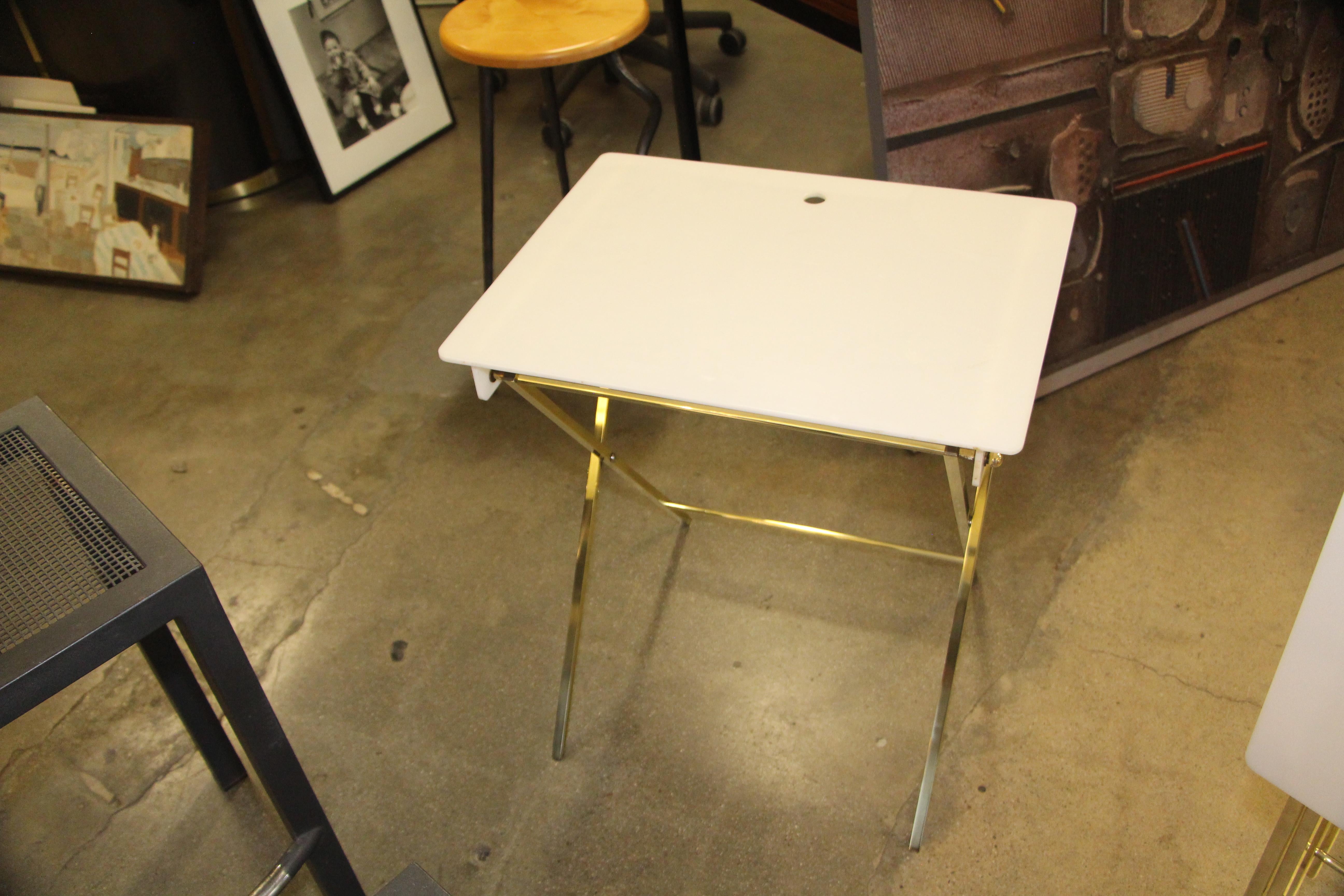 A nice early set of white acrylic and brass folding tables with a matching stand to hold them from when not in use. The acrylic base dates this group to the 1960s as Charles Hollis Jones recently pointed out when he authenticated them as his work on