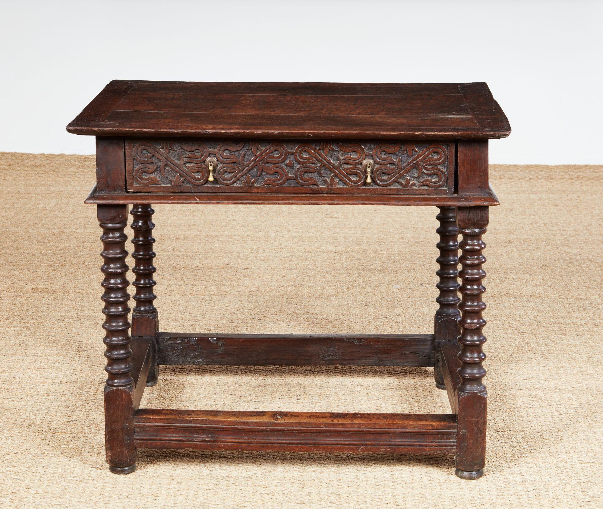 Belle et rare table I+I, le plateau à onglet surmontant un tiroir unique sculpté de sangles, reposant sur de solides pieds tournés reliés par un lourd châssis mouluré, l'ensemble possédant une belle couleur et une patine riche.