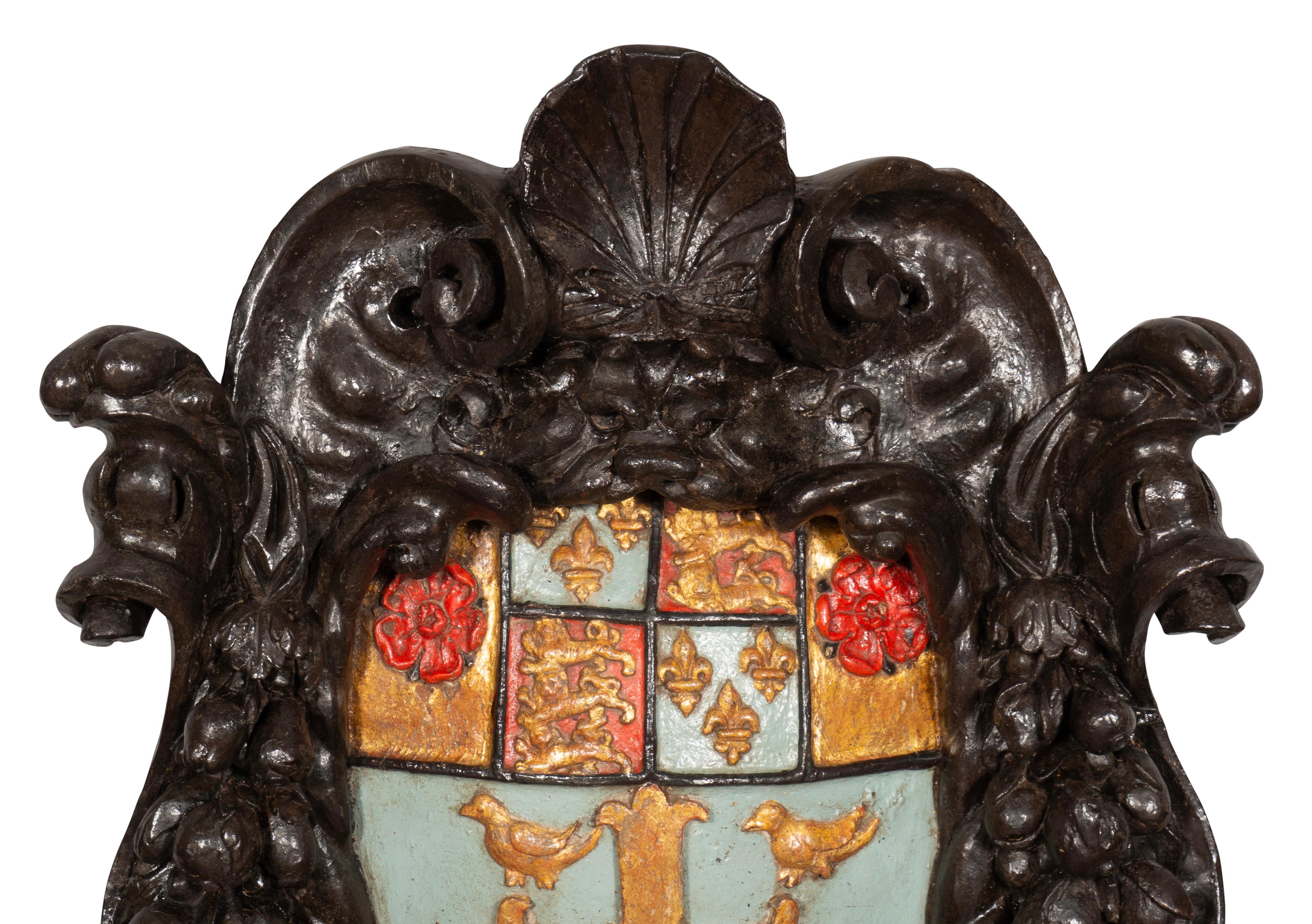 A large crest with shell and scroll carved frame enclosing an azure ground with gilded coat of arms featuring a cross with four birds over lions and fleur de lis and Tudor roses. Only difference between Westminster Abbeys coat of arms and