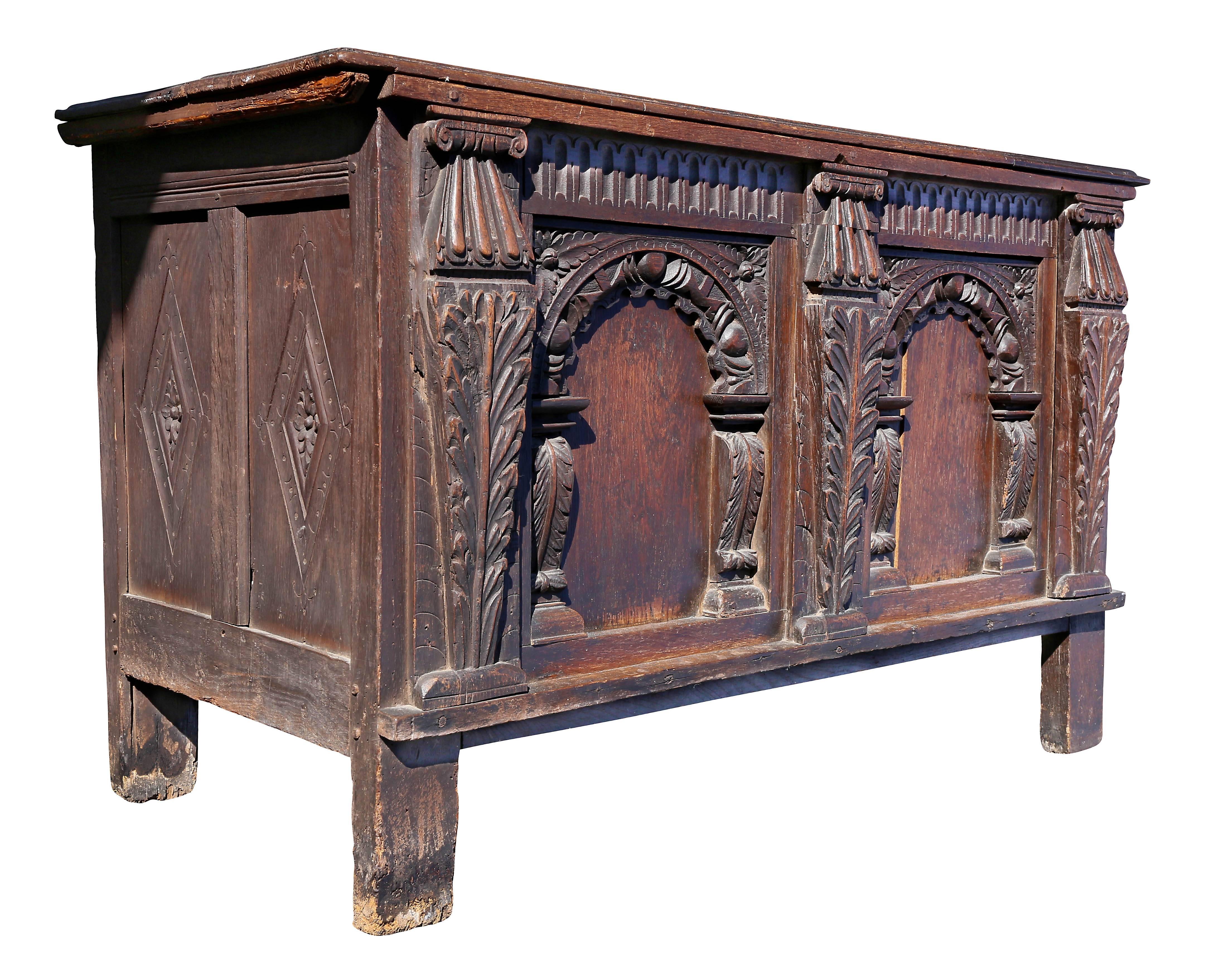 With a two board top over a case section with two panels each with carved arches flanked by acanthus leaf carved columns raised on stile feet.