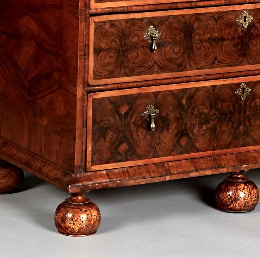 The rectangular cross grain moulded top with well-chosen hand cut olive oysters are carefully laid in geometric patterns, incorporating roundels and corners arcs all banded in holly. Similarly, the two short over three long graduating drawers,