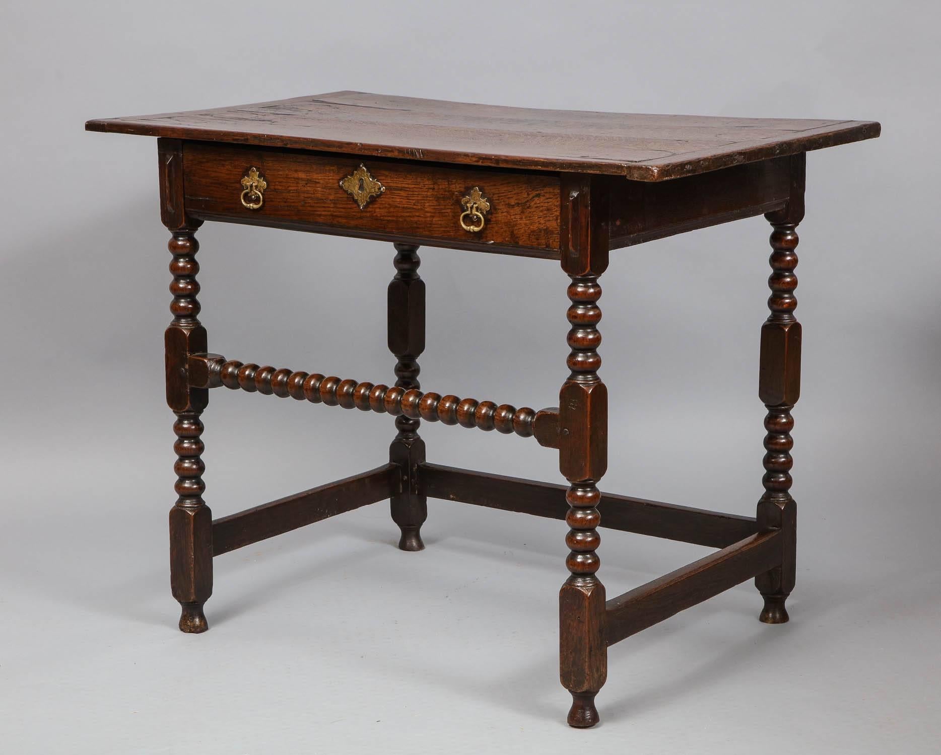 Fine Charles II period oak side table, the three plank top with breadboard ends over single drawer retaining original escutcheon and standing on boldly turned bobbin legs and having desirable high bobbin turned front stretcher and standing on