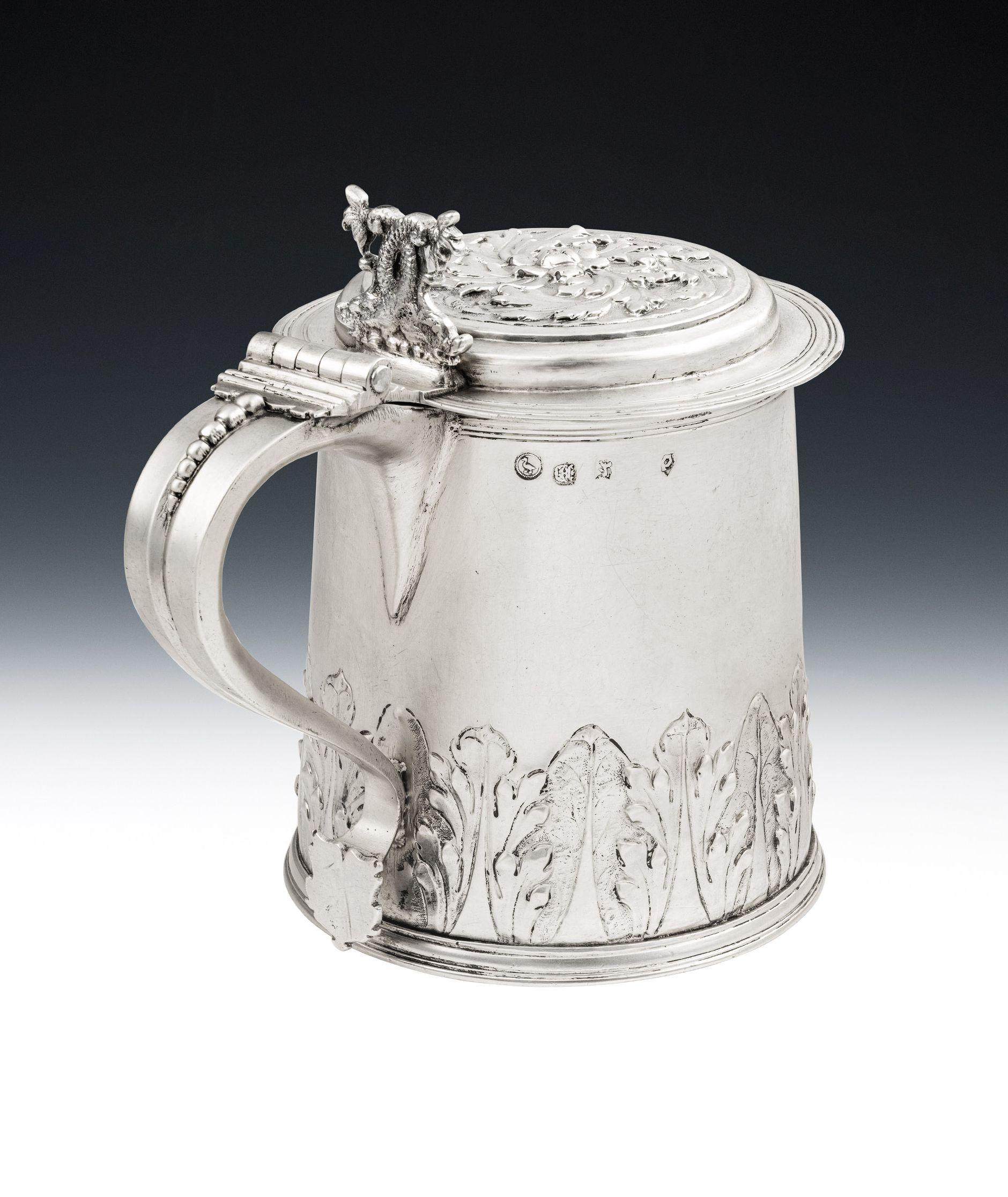 An Important Charles II Tankard and Cover Made in London in 1681 by John Duck

This extremely fine piece is of a large tapering cylindrical form with a reeded skirted base.  The sides are unusually embossed with a lower band of matted acanthus