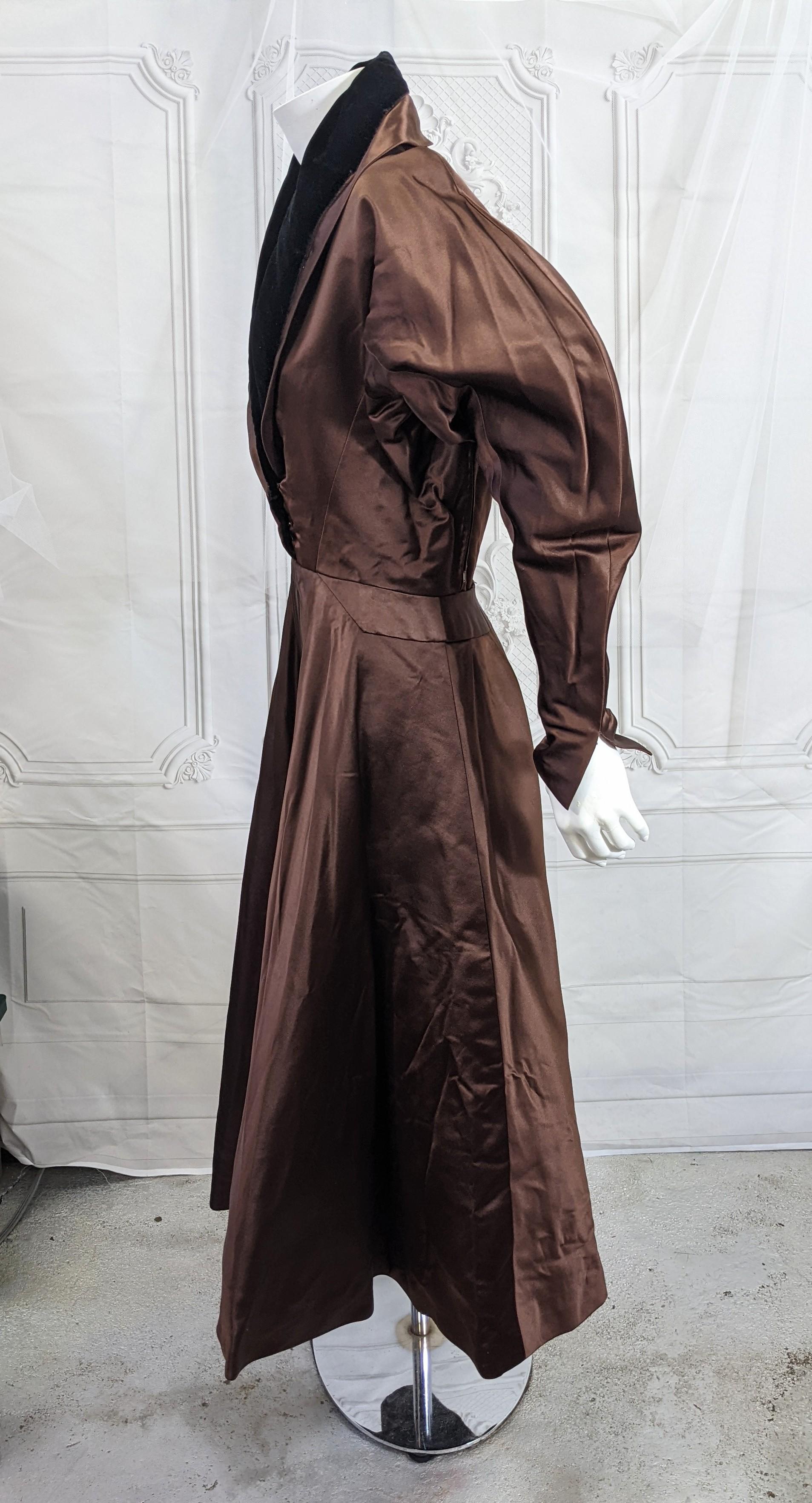 Un raro vestido de cóctel de terciopelo negro satinado Charles James Brown. Este diseño, que data de la década de 1950, se reconoce como suyo en otras fabricaciones.
En esta iteración en satén de seda chocolate intenso, James utiliza su