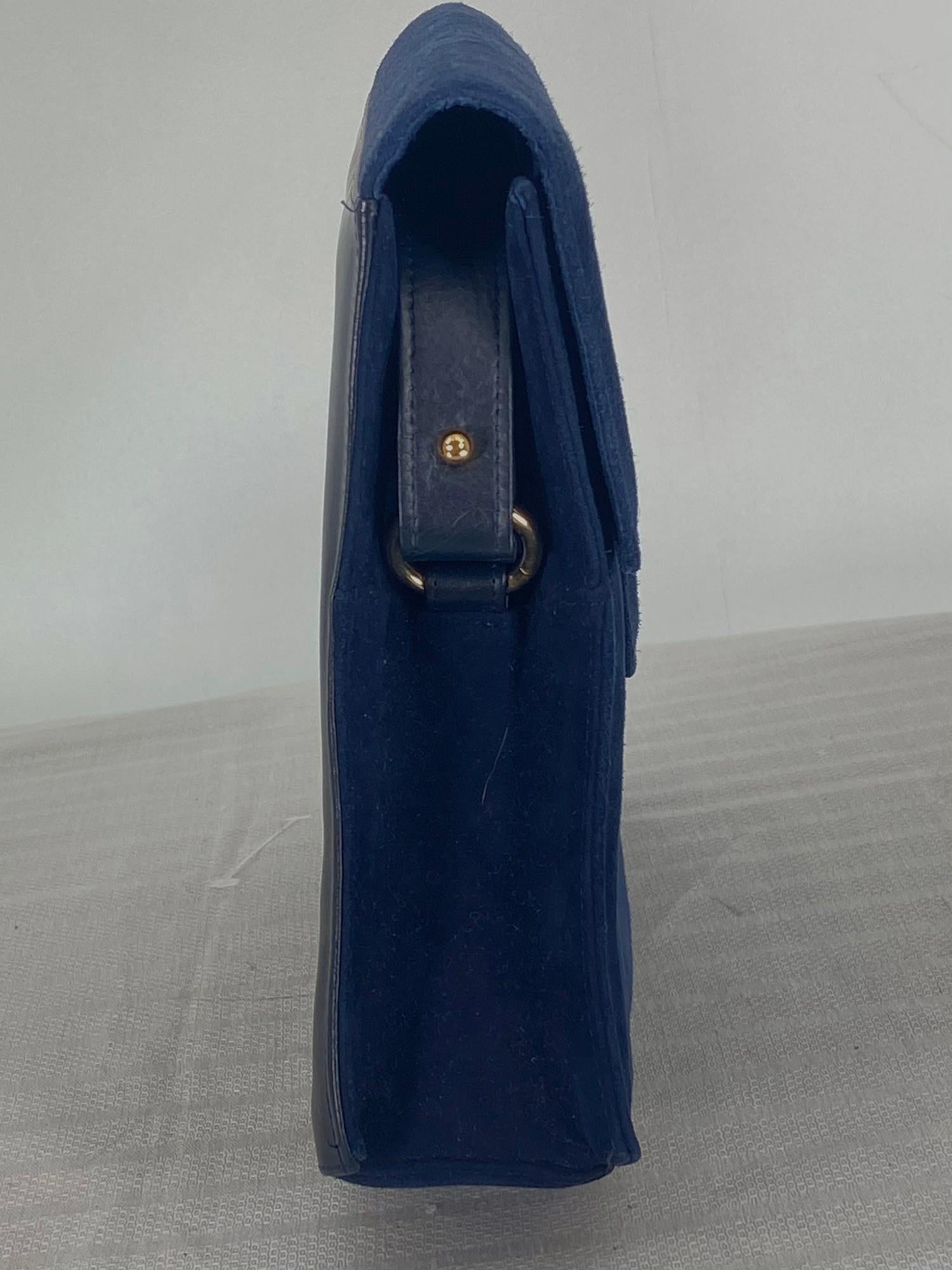 Charles Jourdan navy blue suede & leather shoulder bag with gold hardware from the 1990s. Structured bag with a shaped front flap that has a gold metal bar/hidden magnetic snap closure. The bag front and sides are navy blue suede, the bag back is