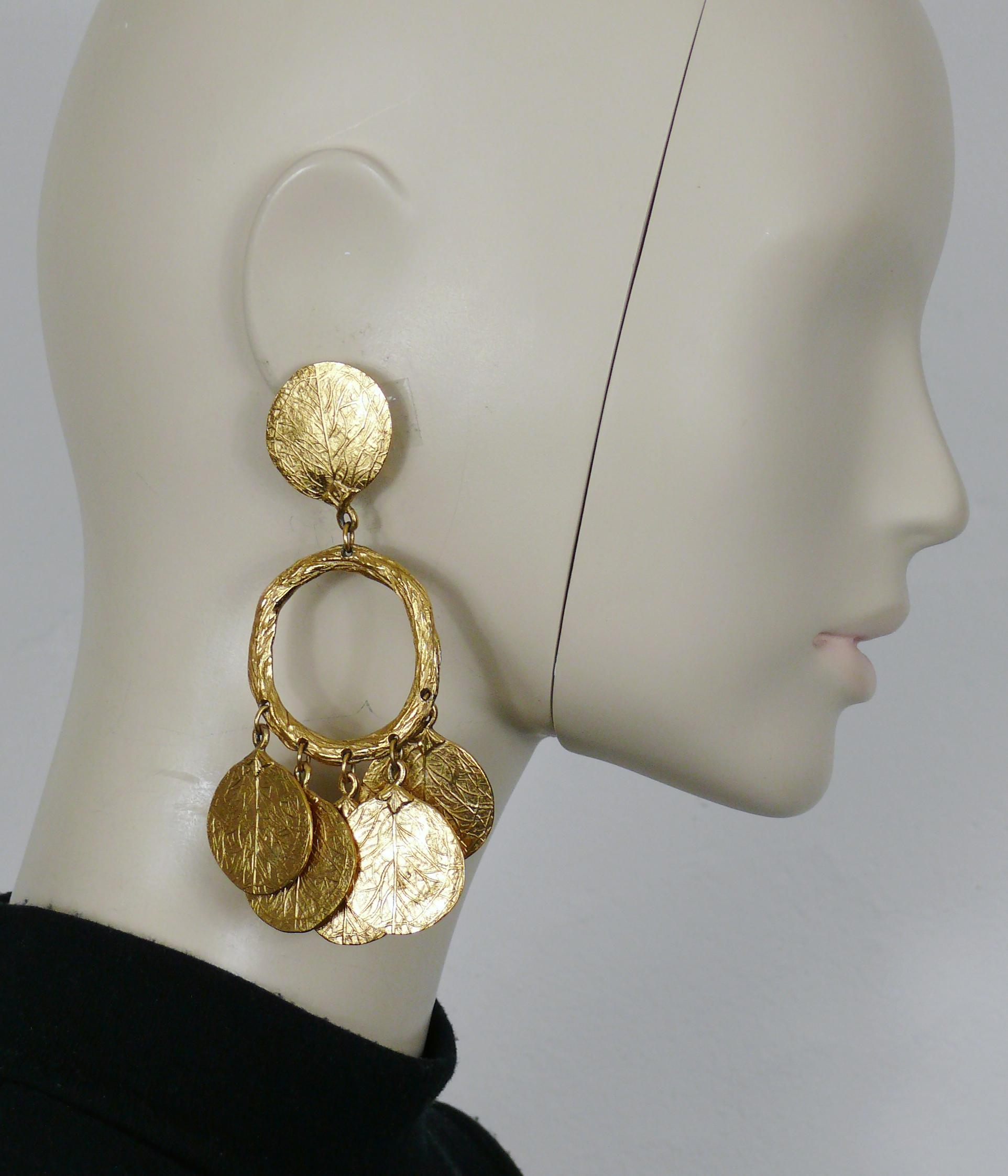 CHARLES JOURDAN - Boucles d'oreilles pendantes (clip-on) vintage, texturées et dorées, avec des breloques en forme de feuilles.

Embossé CHARLES JOURDAN Paris.

Mesures indicatives : hauteur env. 11 cm (4.33 inches) / largeur max. env. 6.5 cm (2.56