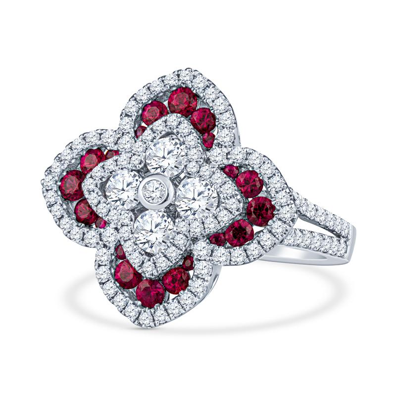 This beautiful and feminine ring features 1.03 carat total weight in round diamonds accented with 0.56 carat total weight in round rubies set in 18 karat white gold. It is a floral shape and set on a diamond encrusted split shank. The ring is a size