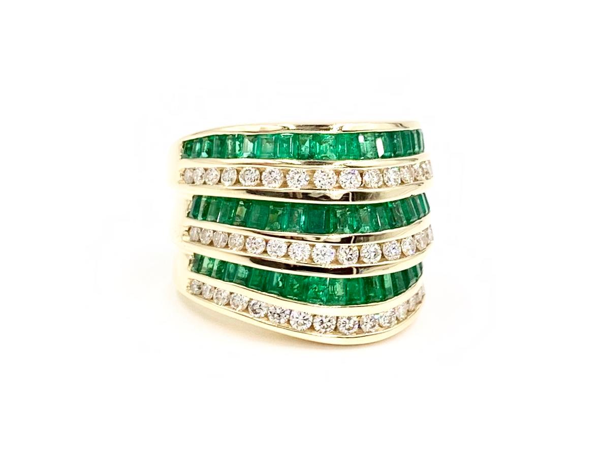A heavy and substantial extra-wide multi-row modern band crafted with superior quality by Charles Krypell. Six stacked rows of alternating channel set diamonds and emeralds is designed with a very slight curve on one edge, giving this band a slight