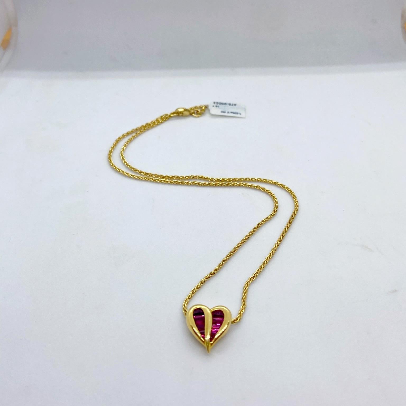 Charles Krypell Jewelry is a New York Based fine jewelry brand that became internationally known for its exquisite use of color, novel designs, and outstanding craftsmanship. 
This 18 karat yellow gold heart is set with invisibly set tapered ruby