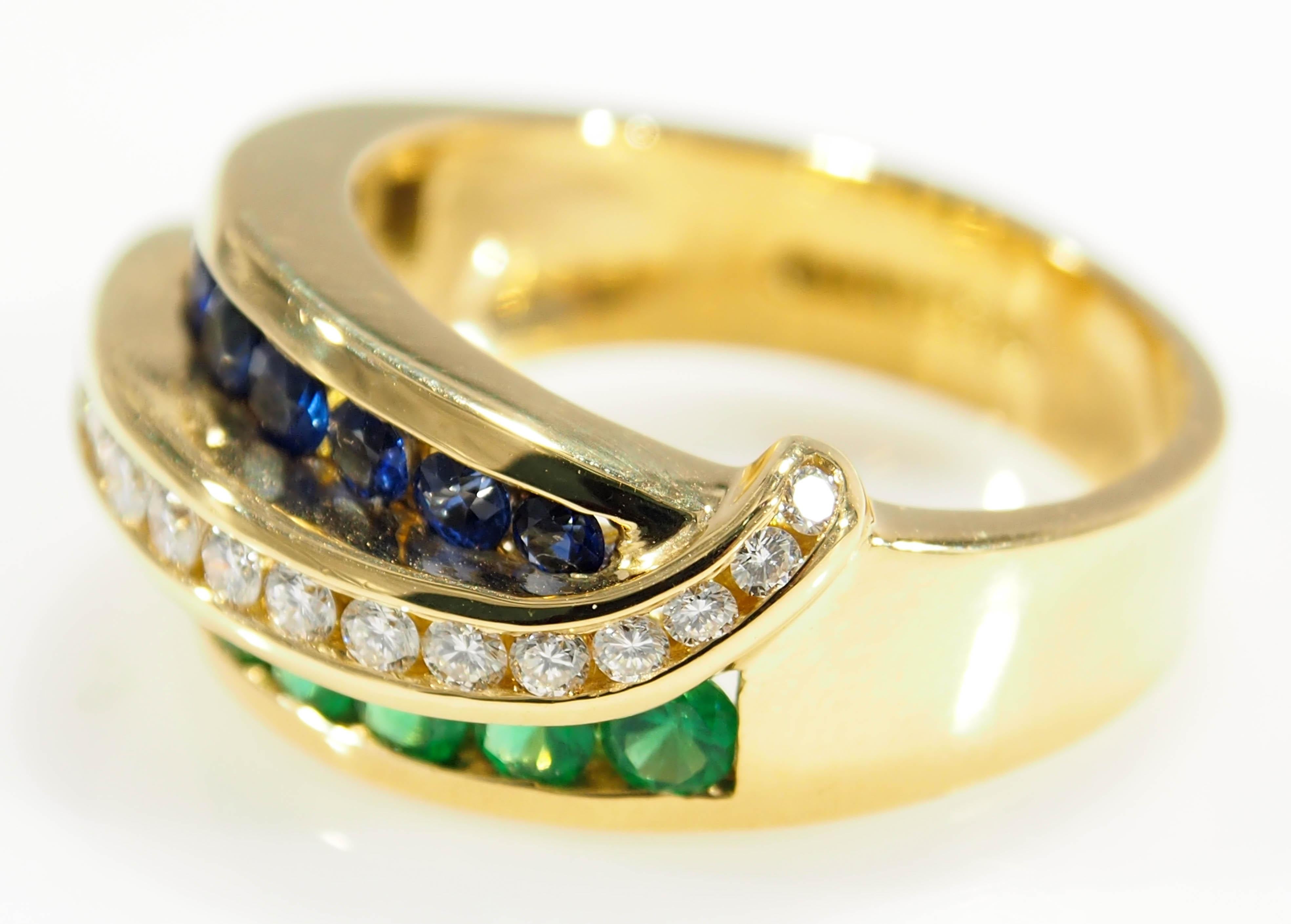 From the talented jewelry artist, Charles Krypell is this lustrous 18 Karat Yellow Gold Ring. A sculpted wave with (21) Round Brilliant Cut Diamonds, G-H in Color, VS in Clarity, 0.21ctw, (9) Sapphires, 0.27ctw, and (9) Emeralds, 0.27ctw. This is a