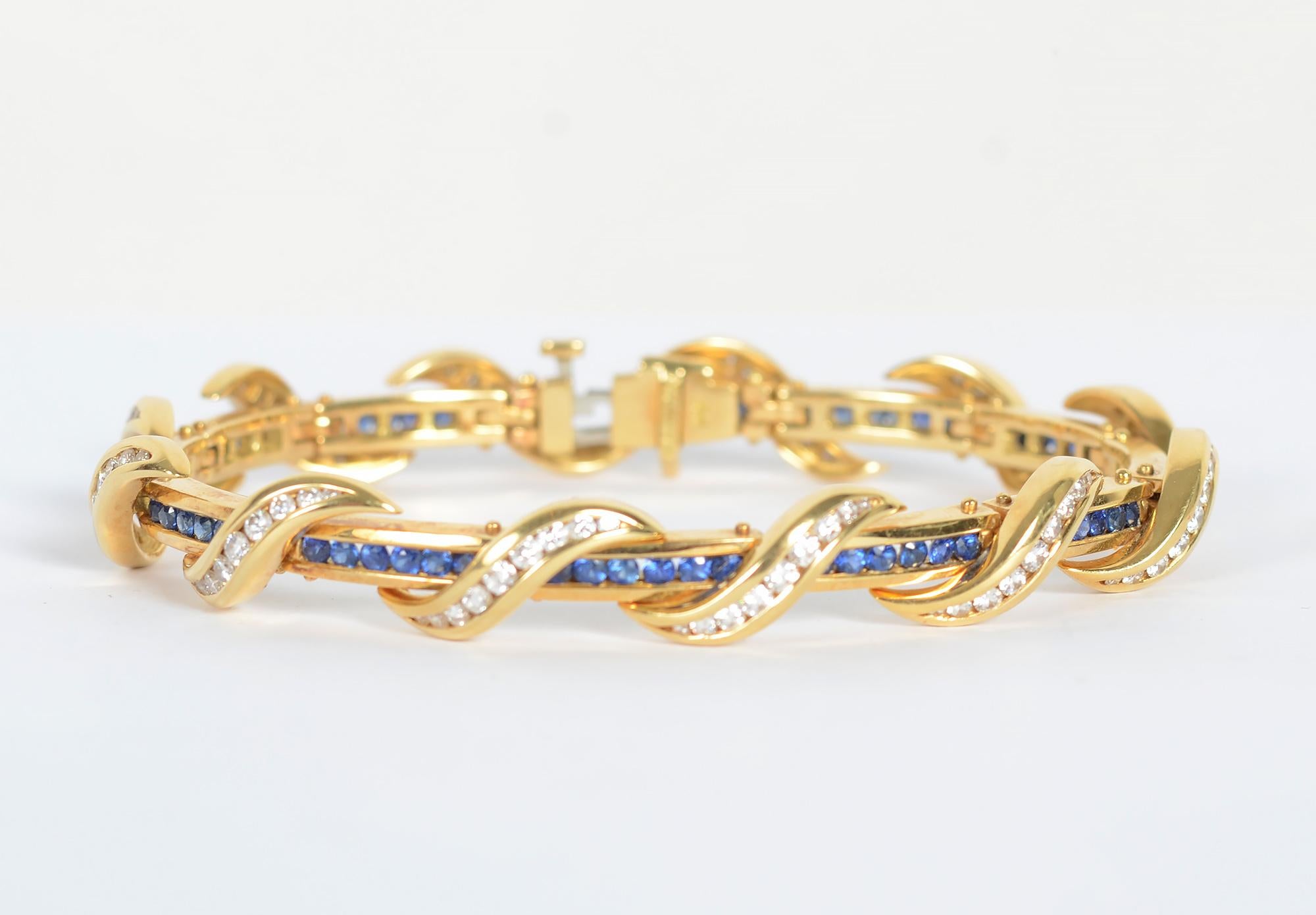 Elegant sapphire and diamond bracelet by American designer, Charles Krypell. Channel set sapphires encircle the wrist with gracefully  curved diamonds overlapping. The bracelet has 108  diamonds with a total weight of approximately 2.5 carats. It
