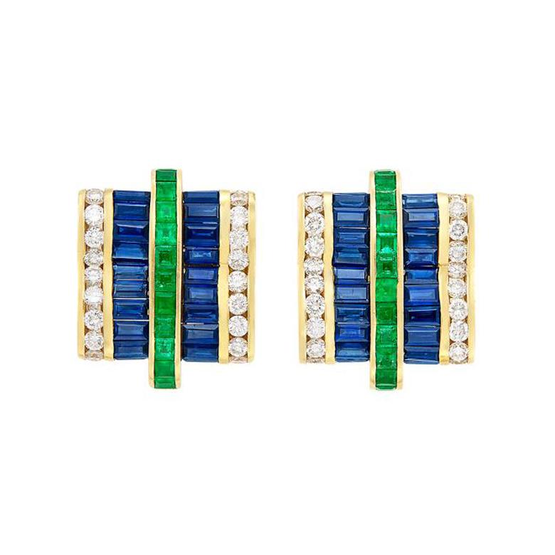 A symmetrical and sophisticated pair of earrings with a slight curve, accented with 24 square-cut emeralds (appx. 1.40 cts), 44 deep blue rectangular-cut sapphires (appx. 7 cts.) and 40 round diamonds (appx. 1.60 cts.) in 18K Yellow Gold.