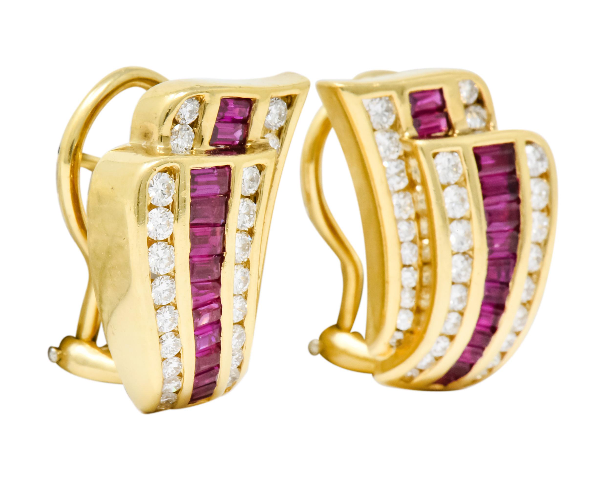 Earrings designed as two offset, curved, tapered formations with a polished gold finish

Centering a channel set row of baguette cut rubies weighing approximately 1.10 carat total, transparent and raspberry red in color

Flanked by channel set round