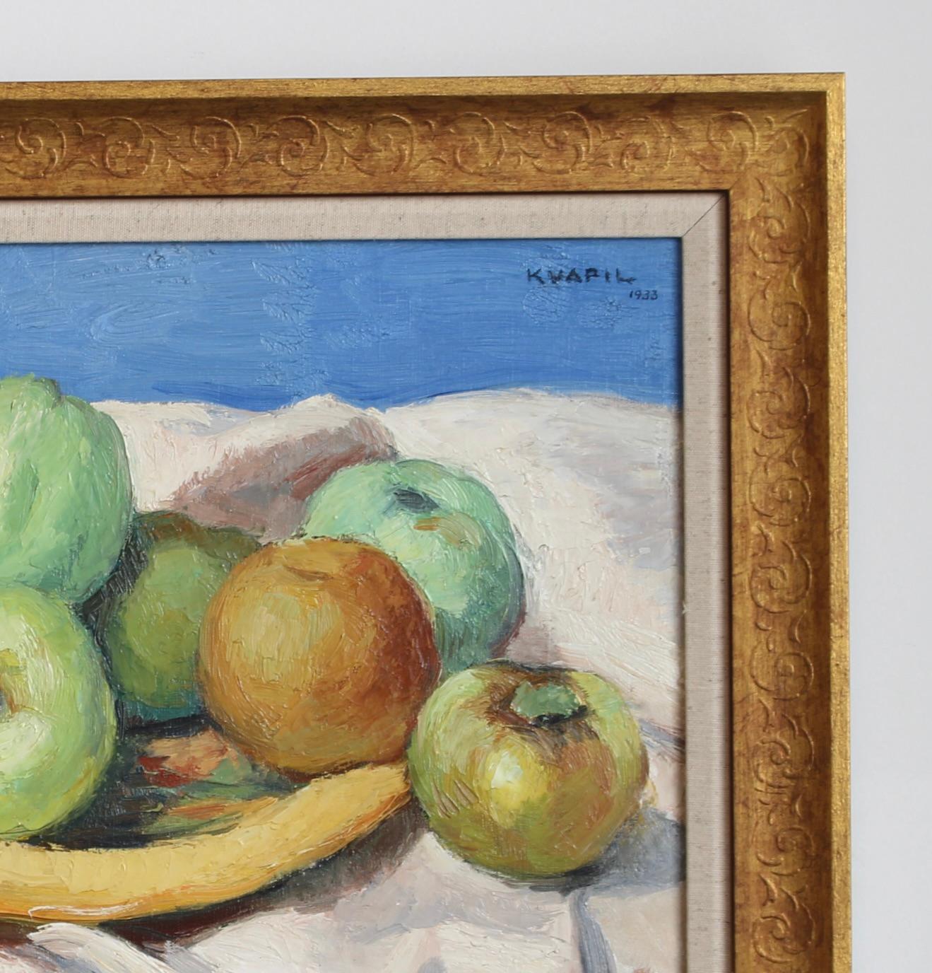 Une saisissante nature morte, huile sur toile (1933), de Charles Kvapil, peintre d'origine belge qui s'est illustré à Paris au début du XXe siècle. Cette composition signée et datée représente un groupe de pommes et une banane disposées sur un drapé