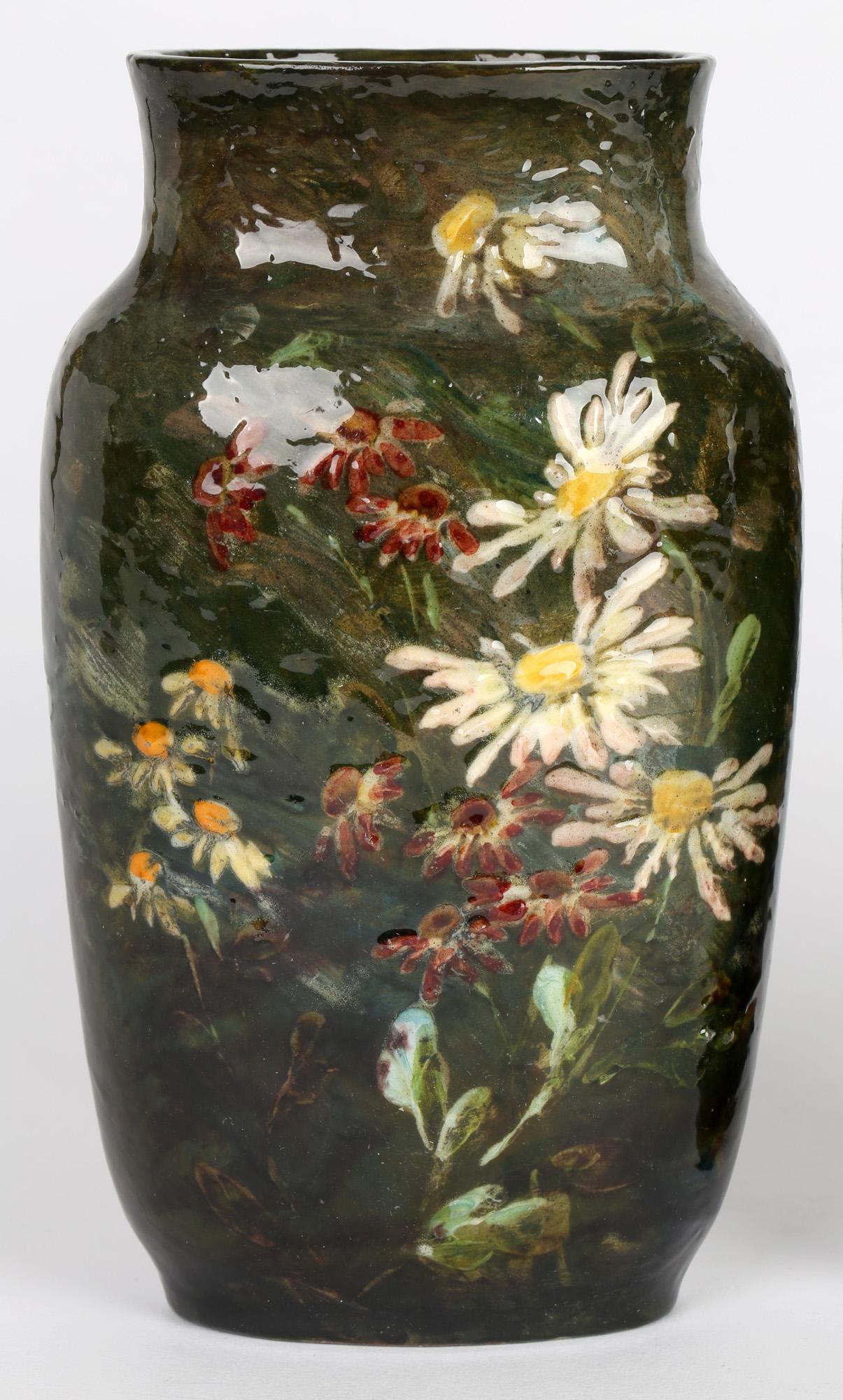 A fine pair French Montigny Sur Loing art pottery vases decorated with floral designs by renowned artist Charles Louis Eugène Virion (French, 1865 - 1946) and dating between 1890 and 1919. The stunning pair of earthenware vases are of flattened oval