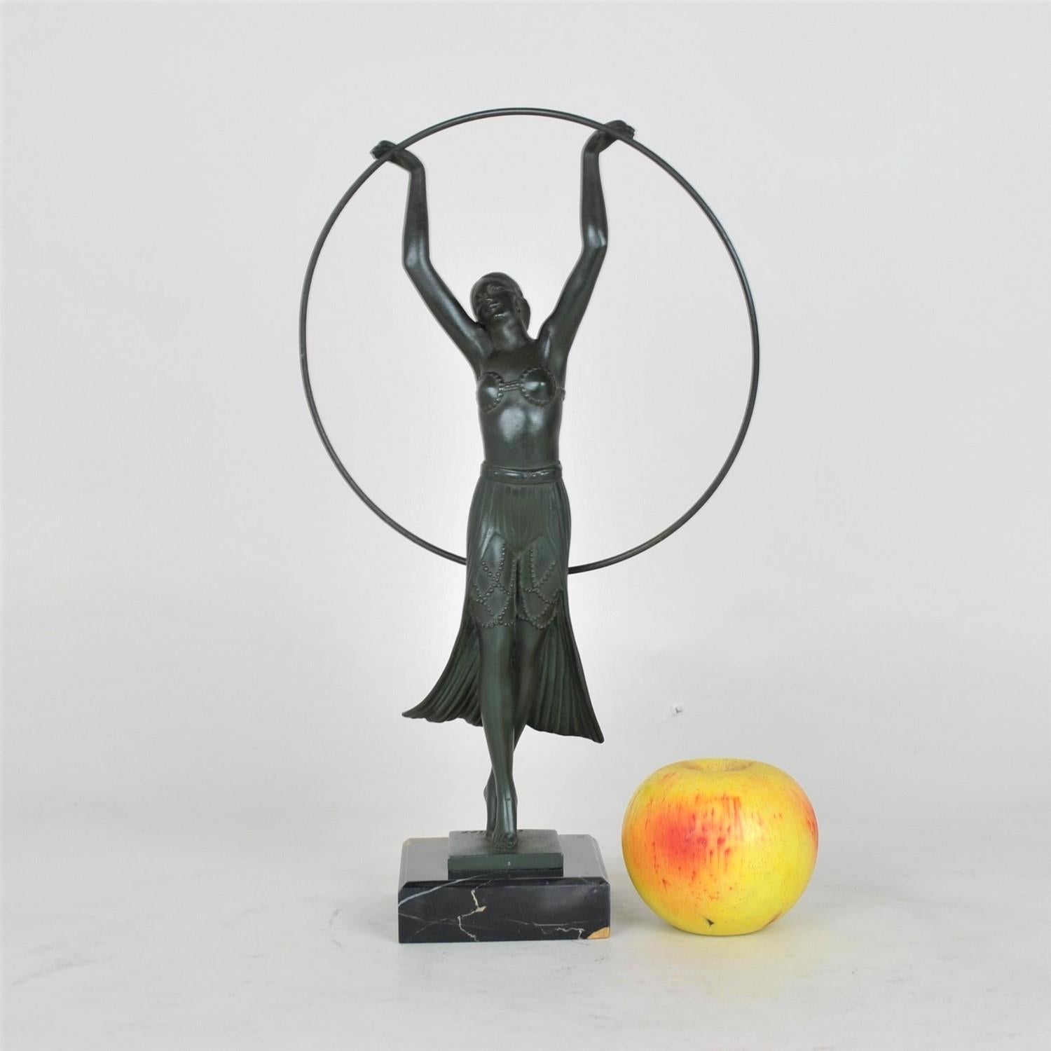 La Bayadère: Sculpture representing a dancer with a hoop, dressed in an exotic costume, and inspired by the ballet character created by Marius Petitpa

Spelter with green patina on a marble base, the counter-base is signed by the artist Charles,