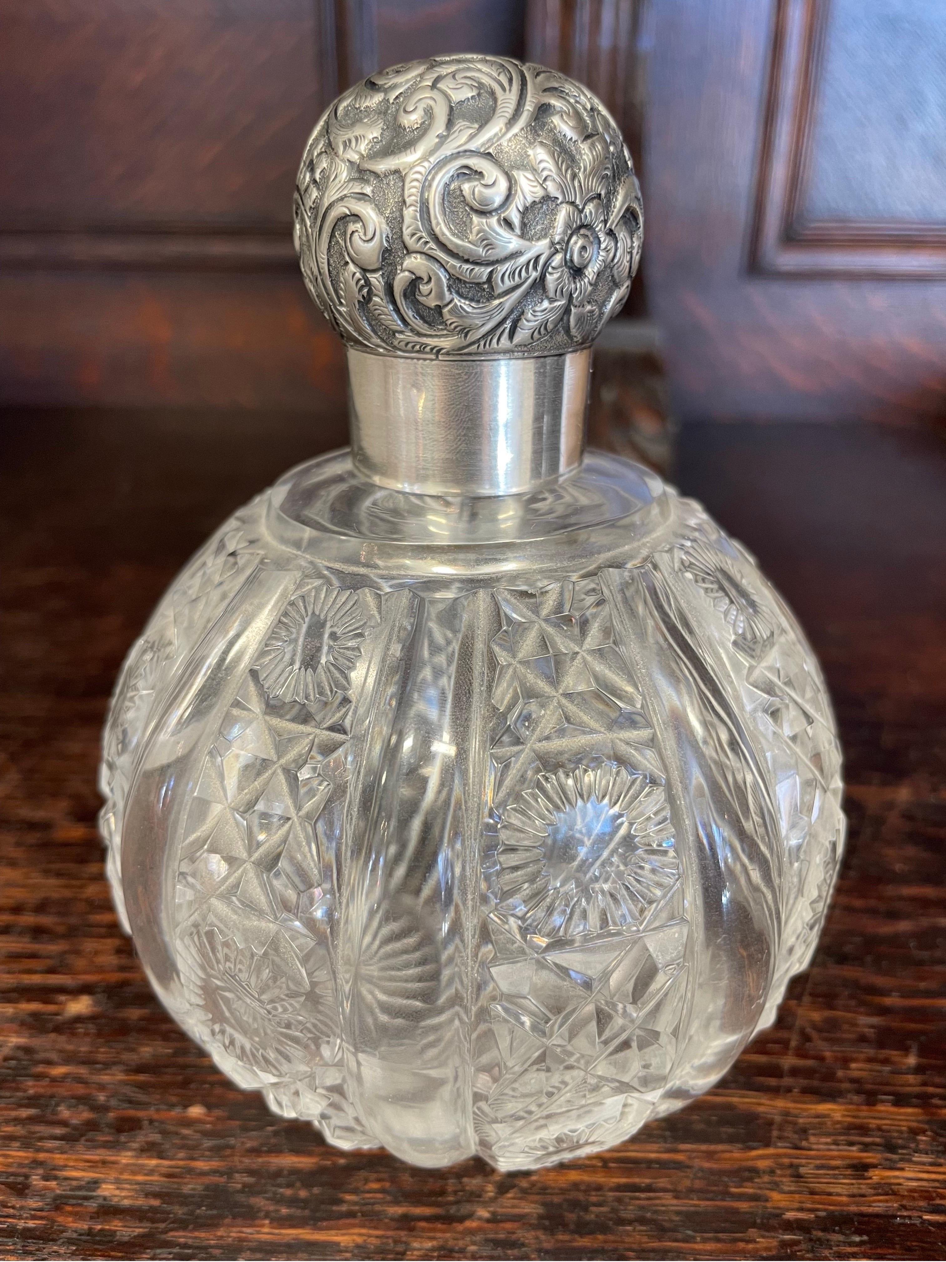 A fine 19th century english sterling silver and cut glass perfume bottle crafted by silversmith Charles May. Fully hallmarked to neck of bottle.