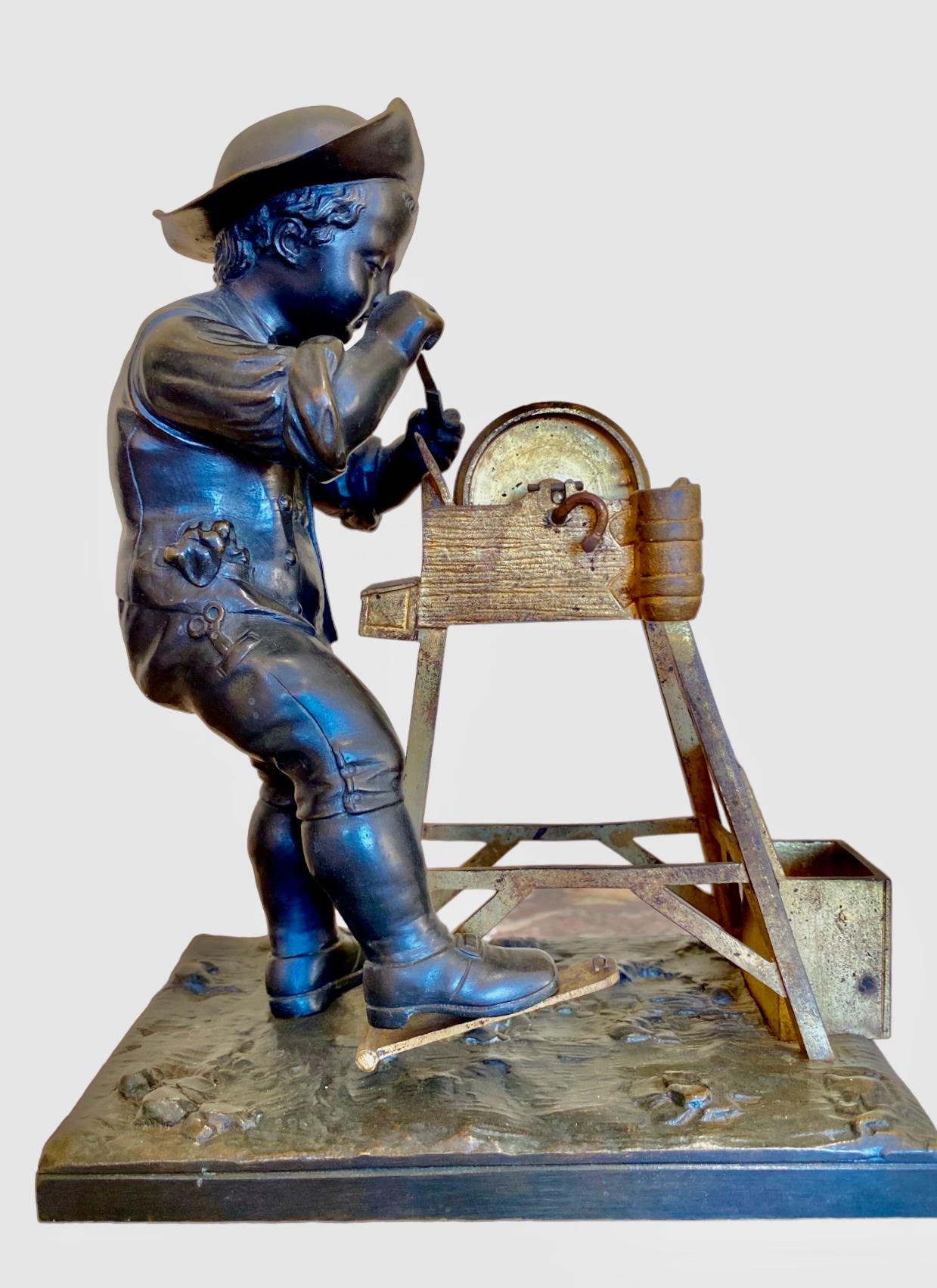 Sculpture in gilded and patinated bronze depicting a small grinder. Signed on the terrace 