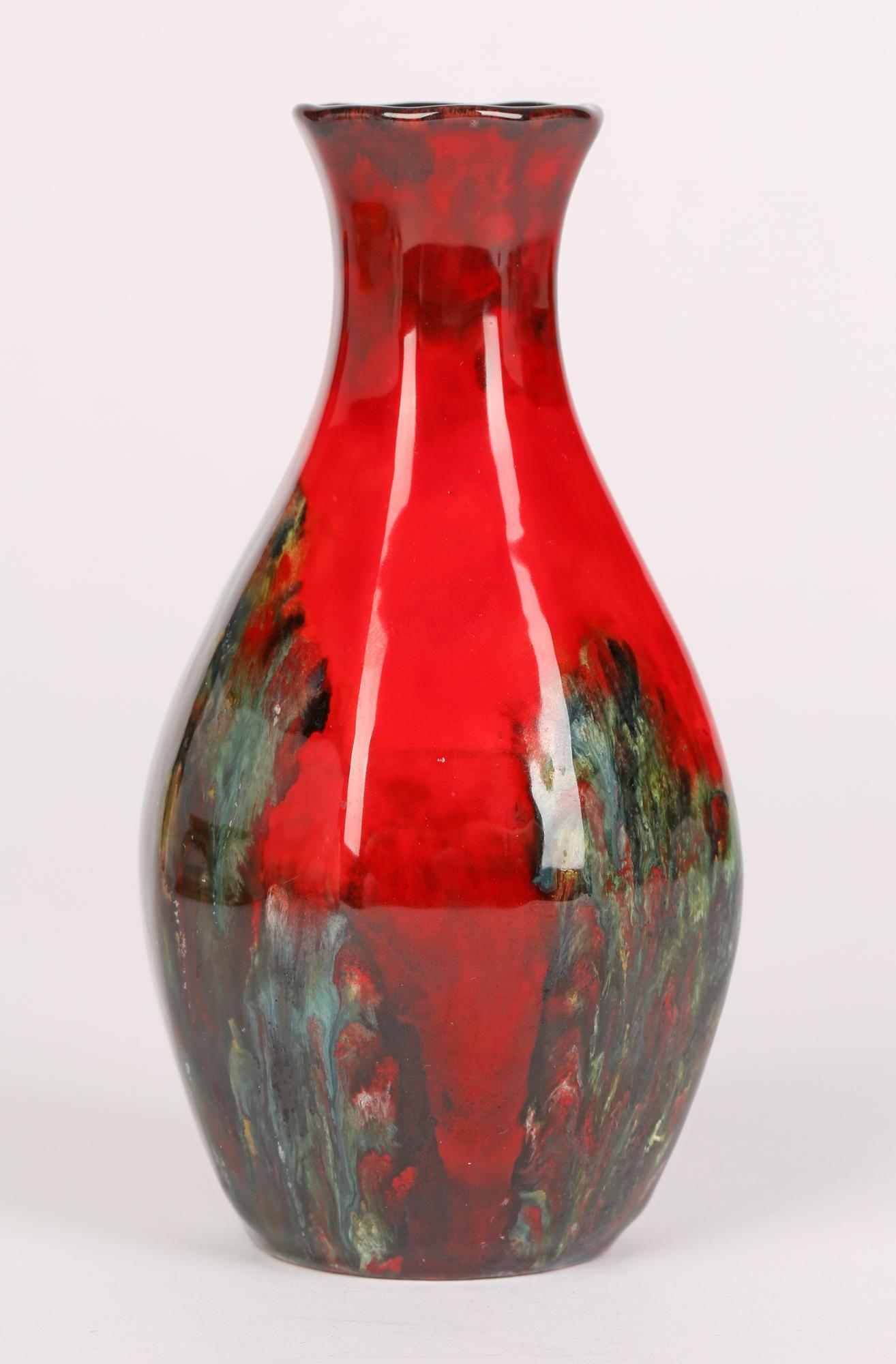 A Royal Doulton Sung Ware art pottery vase decorated with abstract designs on a flambe glazed red ground designed by Charles Noke and Fred Moore dating from around 1920. The hexagonal shaped vase is marked to the base with artist signatures.

In
