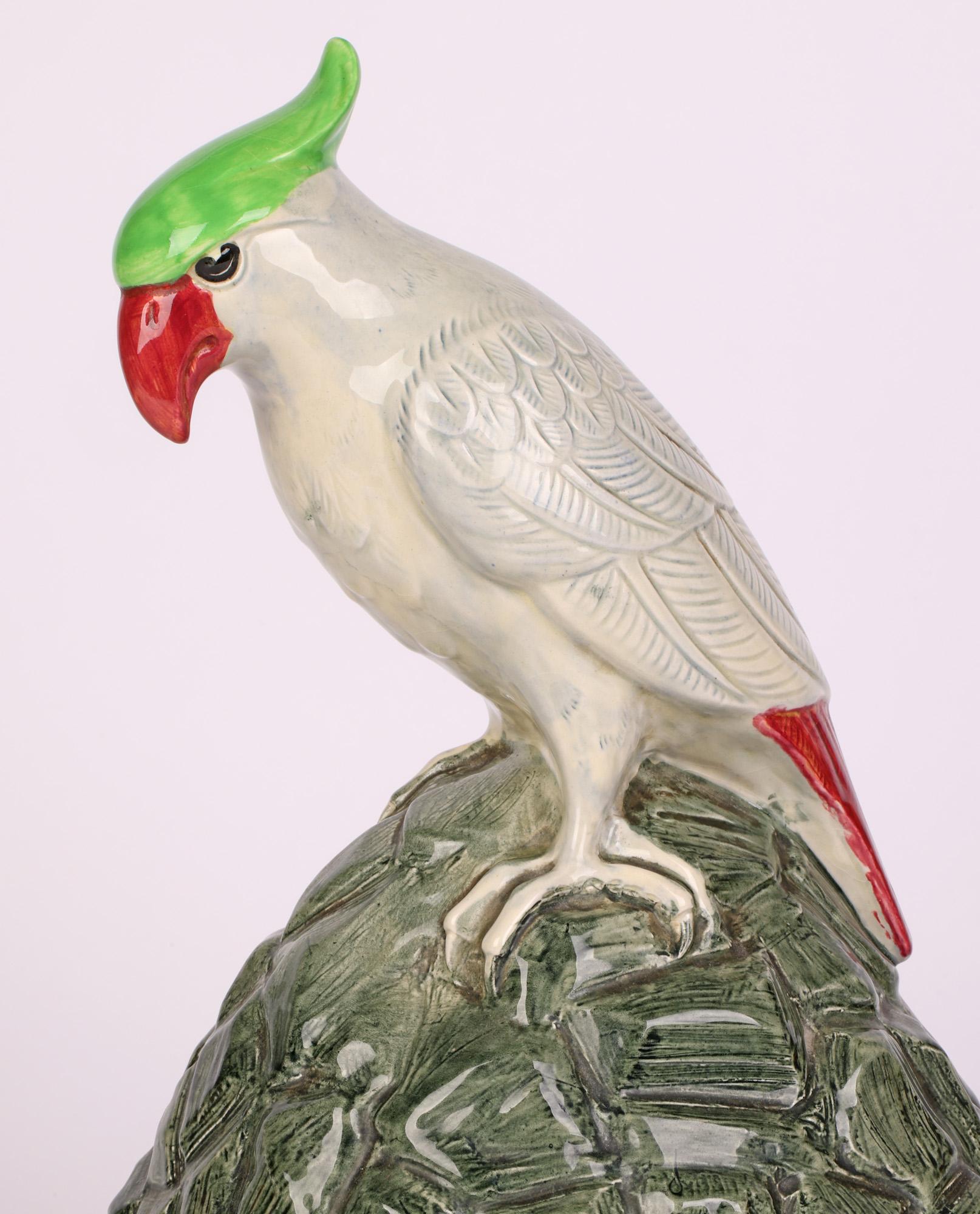 A rare art deco Royal Doulton pottery speaker cover made for Artandia Limited mounted with a cockatoo and designed by renowned artist Charles Noke (British, 1858-1941) and dating from around 1920. The well potted speaker cover stands raised on a