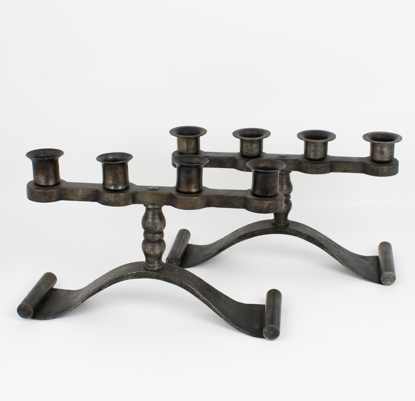 Charles Piguet (1887 - 1942) designed and crafted this stunning pair of wrought iron candelabras in the 1920s. The modernist design features a four-candle-holder shape with a medieval-inspired flair. The candlesticks have the original gunmetal