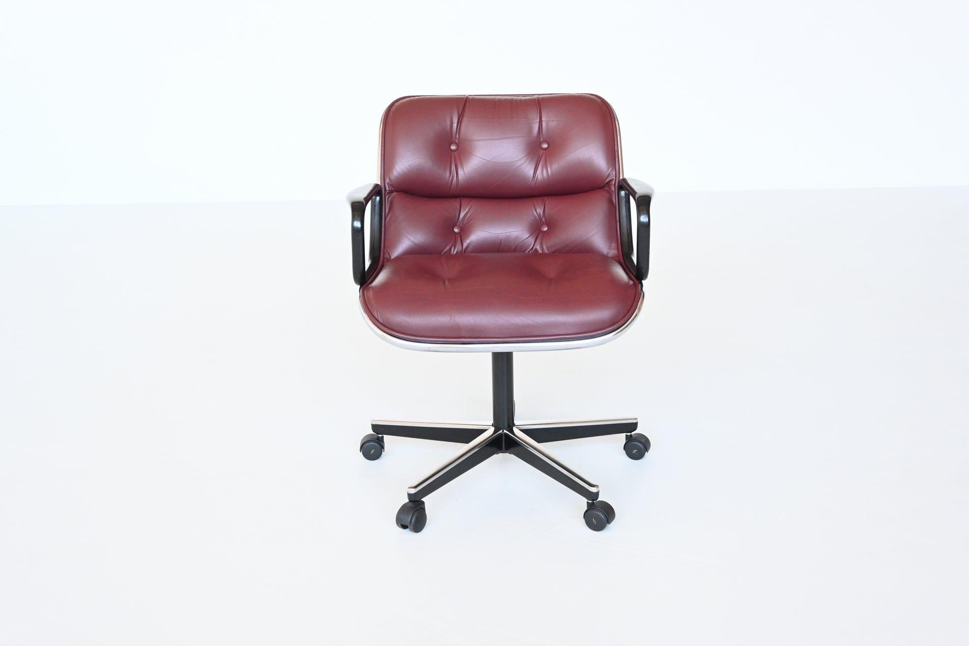 Comfortable executive desk chair designed by Charles Pollock and manufactured by Knoll International, United States 1963. This desk chair is made of high quality burgundy red leather, has a chrome plated rim and footrests and plastic arms. The