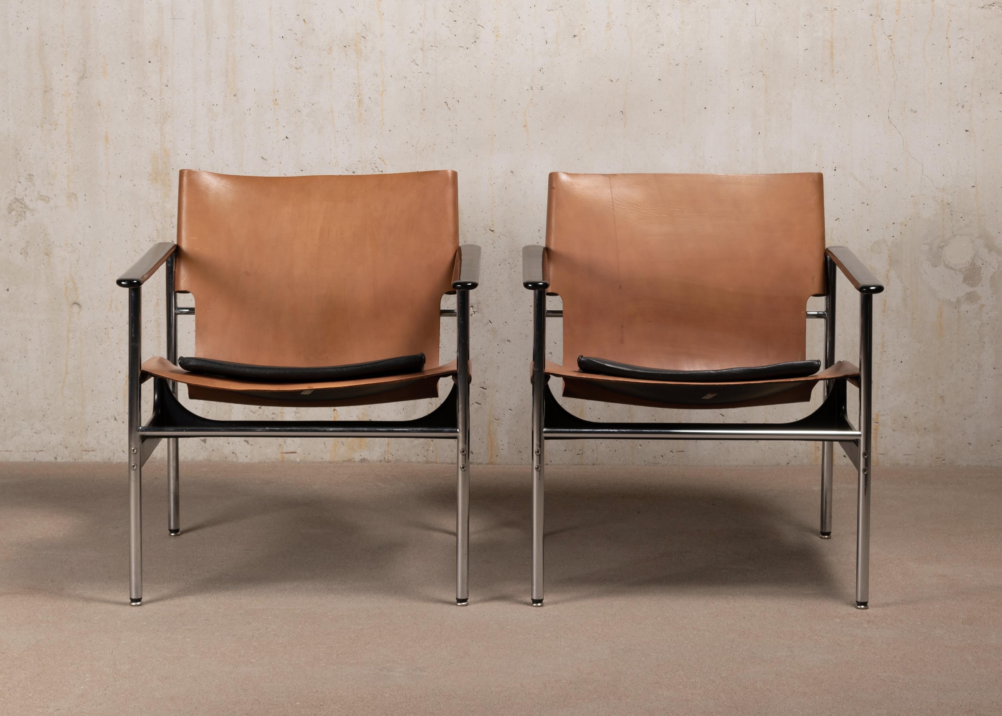 Comfortable pair lounge / easy armchairs by Charles Pollock for Knoll Associates Inc. Tubular chrome plated and black powder coated steel frame, cognac saddle leather with separate black leather cushions. All in very good condition with slight