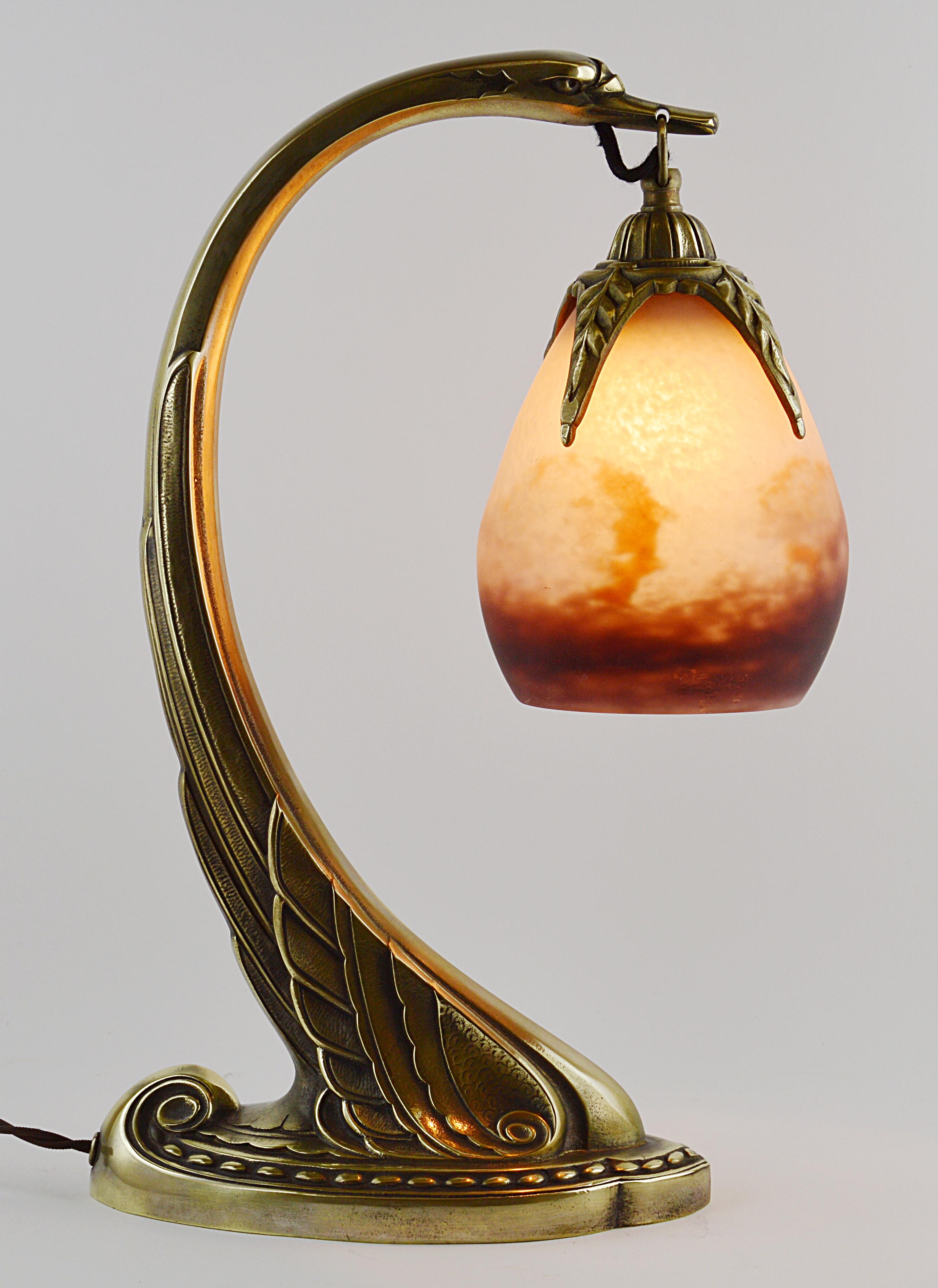 French Art Deco table or desk lamp by Degue(Compiègne) and Charles Ranc (Paris), France, ca.1925. Blown double glass shade by Degue hung at its bronze swan base by Charles Ranc. Colors: purple, white and ochre. Dimensions: 14.2 in. H x 3.9 in. W x
