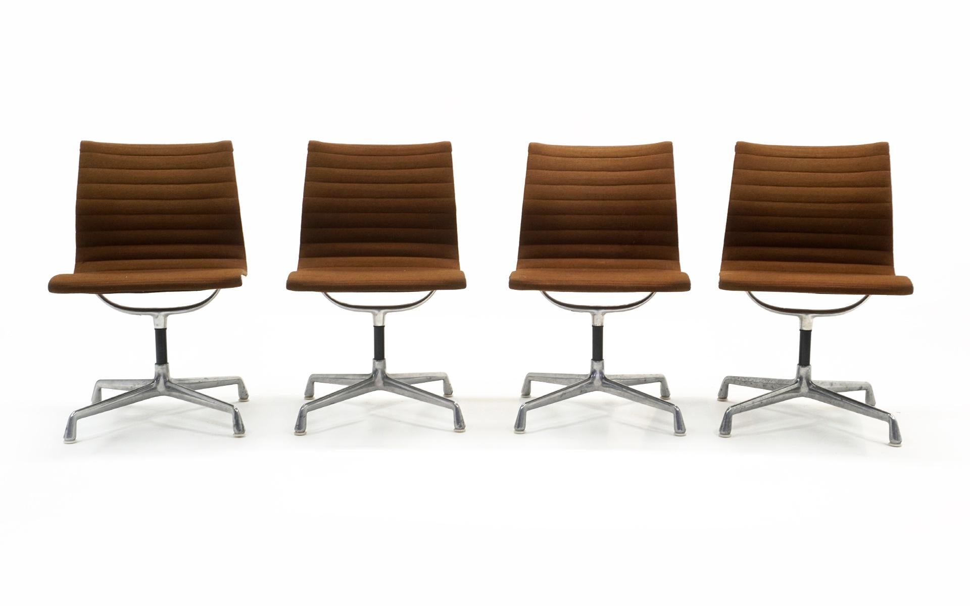 Four Charles and Ray Eames Aluminum Group Chairs. Price is for Each. Cast aluminum, original brown upholstery, with swivel mechanisms that work perfectly. The upholstery shows some signs of wear with no holes or tears. The aluminum bases show signs
