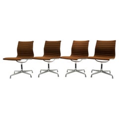 Charles & Ray Eames Armless Aluminum Group Swivel Chairs. Aluminum, Brown Fabric