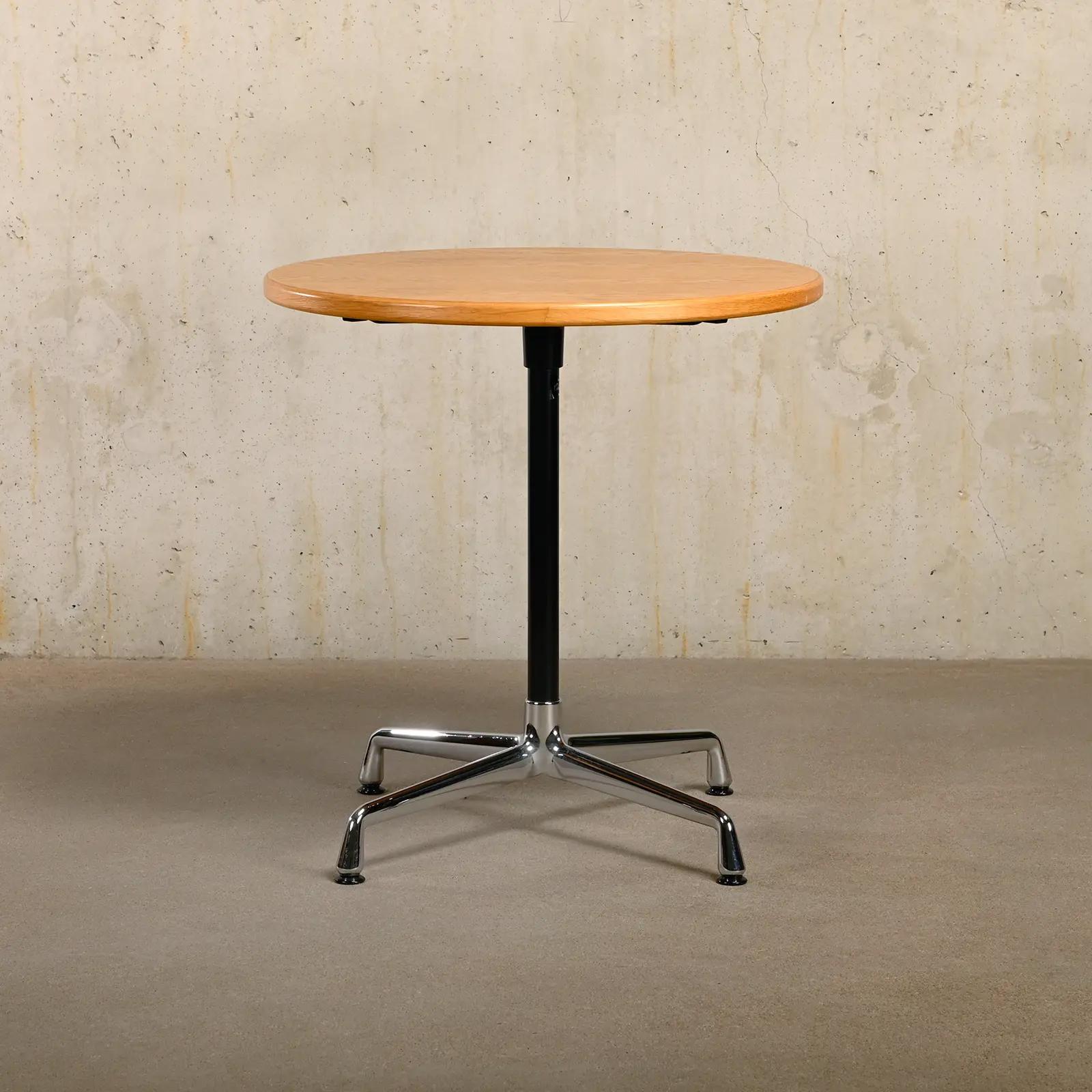 Elegant small dining or bistro table by Charles & Ray Eames for Vitra. The table has a chrome-plated aluminum base with a powder-coated stand and a table top veneered with oak and solid oak edge. Table top diameter 70 cm. Table is in very good