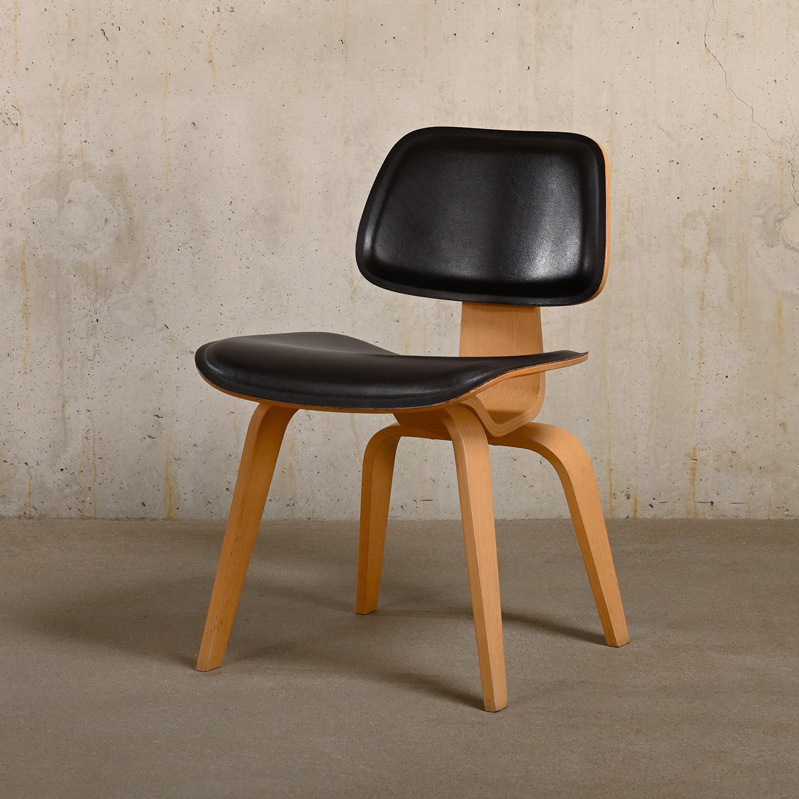 Chaise de salle à manger iconique DCW conçue par Charles & Ray Eames et fabriquée par Vitra, Allemagne. Cadres en bois de frêne massif, finition laquée mate. L'assise et le dossier sont recouverts d'un cuir brun très foncé et soutenus par des