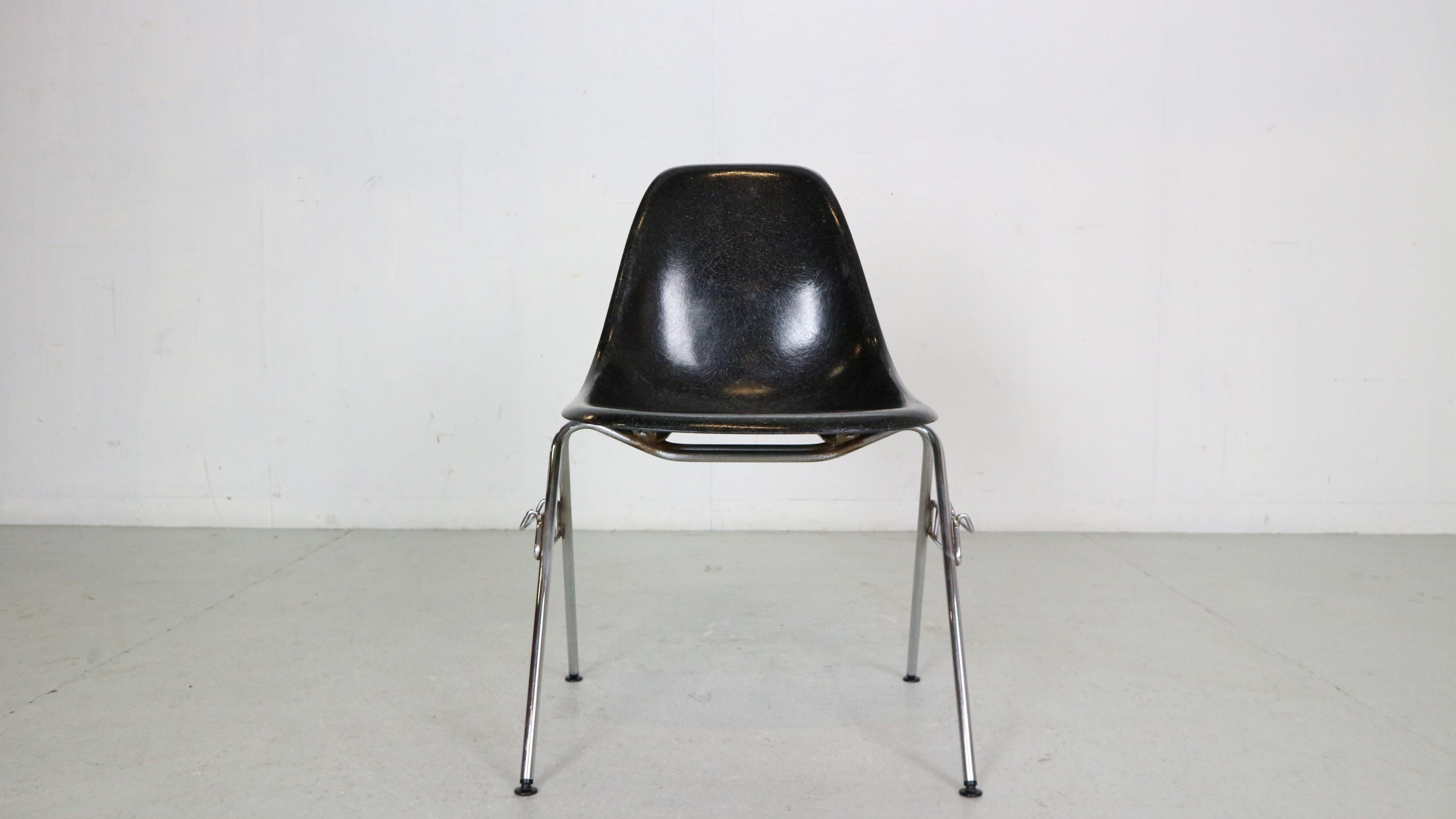 Stapelbare Esszimmerstühle aus der Mitte des Jahrhunderts, entworfen von den berühmten Möbeldesignern Charles & Ray Eames für Herman Miller in den 1970er Jahren, etwa.

Eine geformte schwarze Glasfaserschale mit großer Struktur ist auf einem