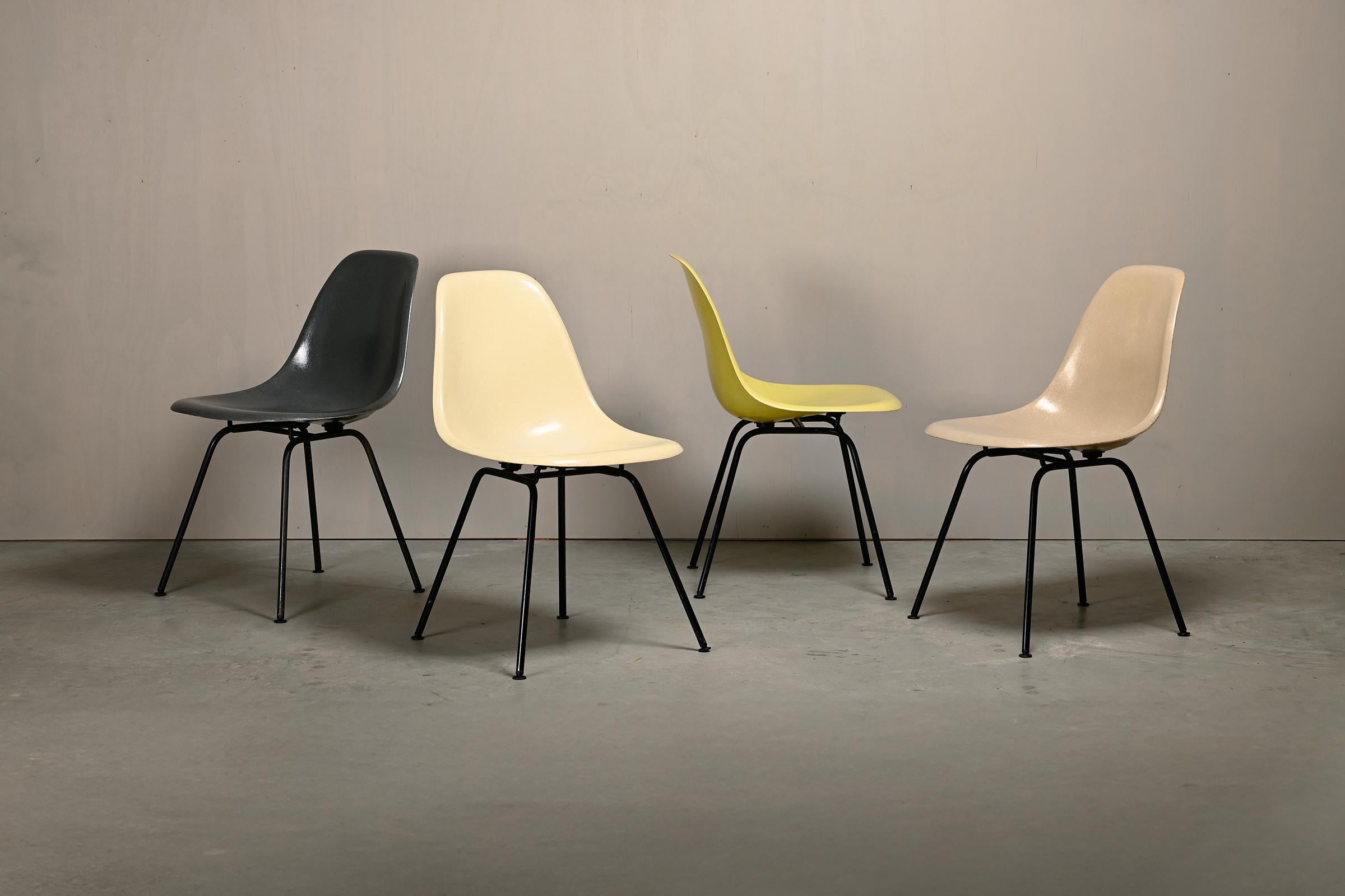 Chaises iconiques conçues par Charles et Ray Eames pour Herman Miller. Coquilles en fibre de verre moulée dans les couleurs : Elephant Hide Grey, Parchment, Lemon Yellow et Greige. Montés sur des socles en H en acier noir vintage. Les chaises sont